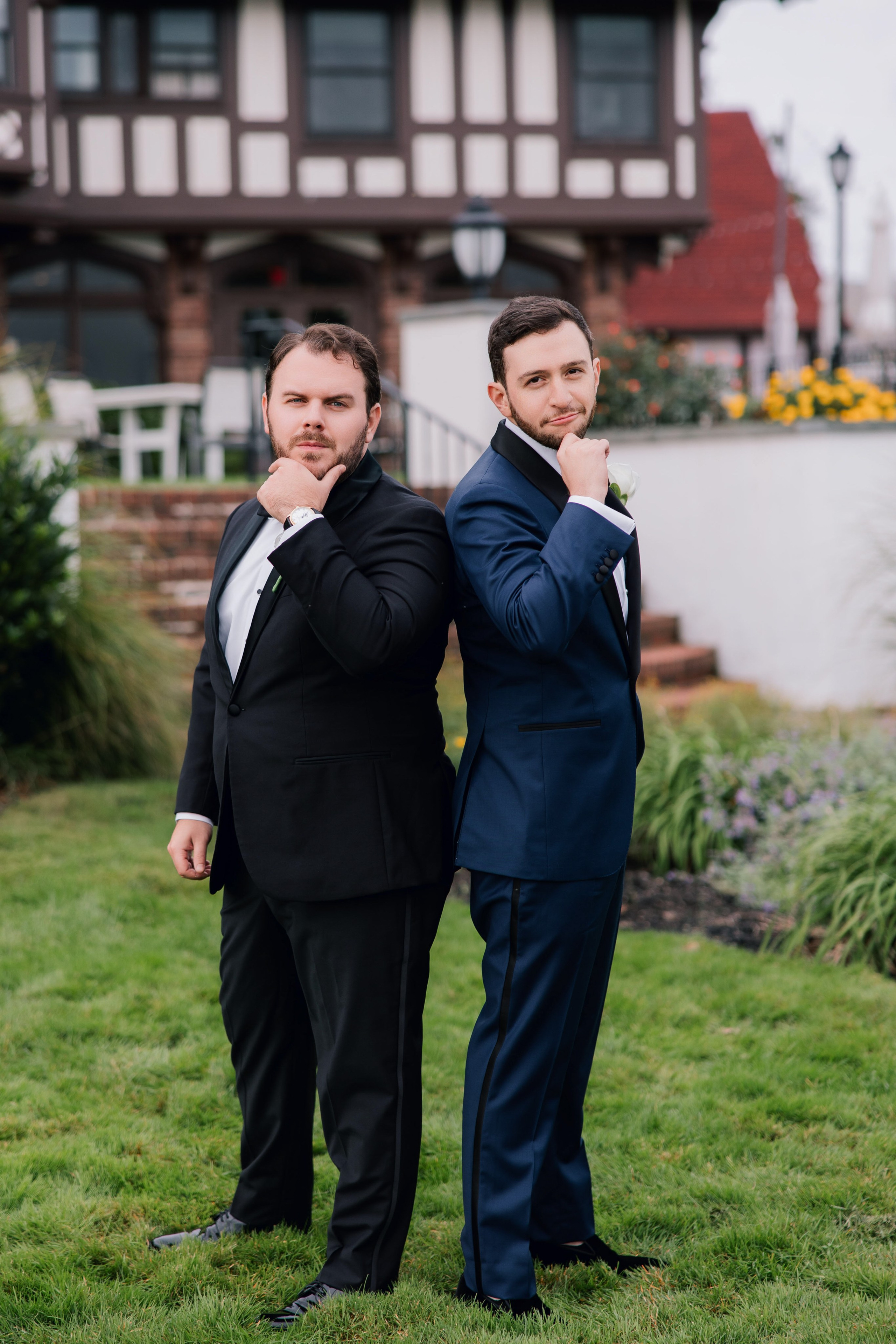 two men in suits standing in the grass
