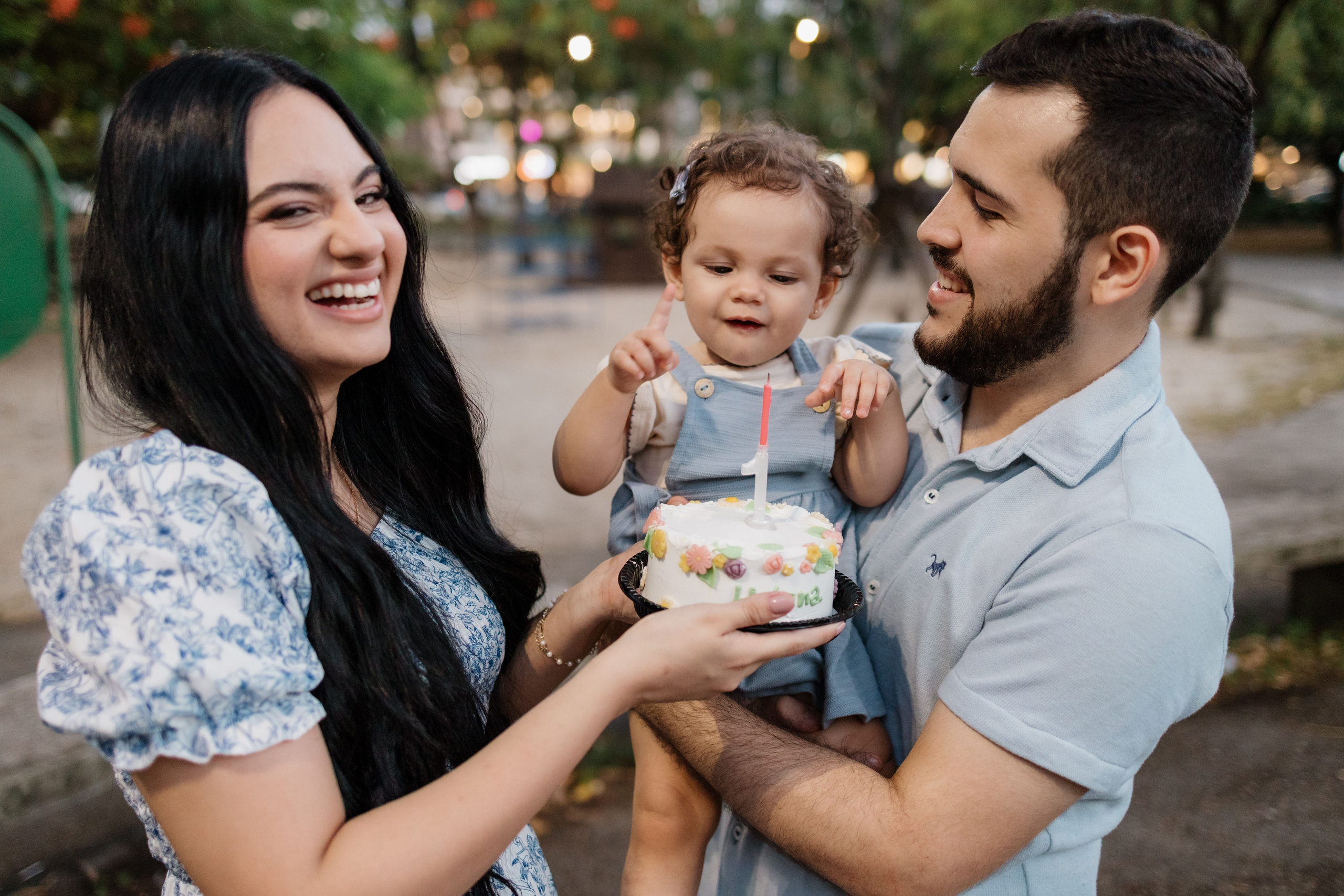 Família cantando parabéns de 1 ano em ensaio no parque