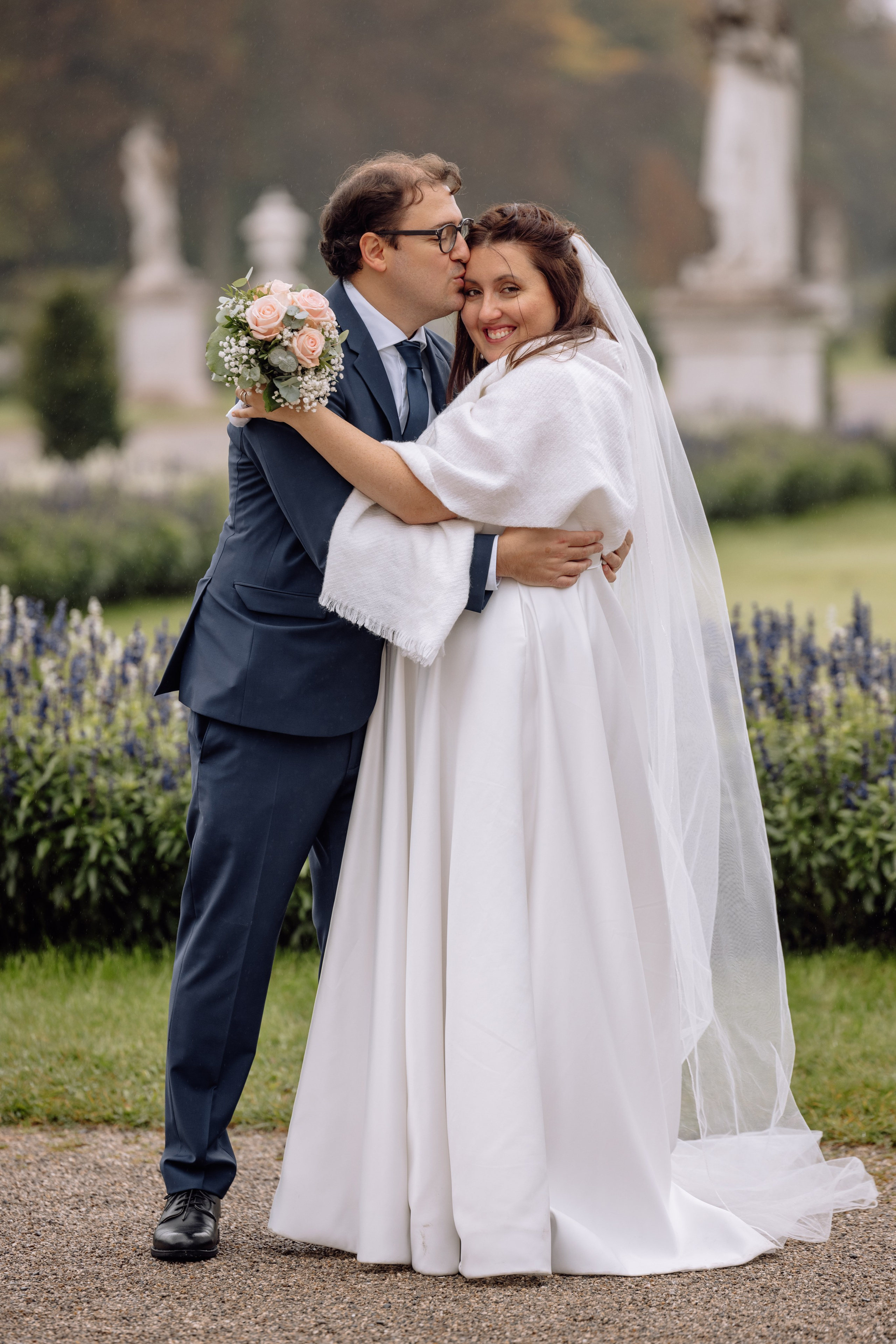 Bräutigam küsst die Braut vor dem Schloss Nymphenburg