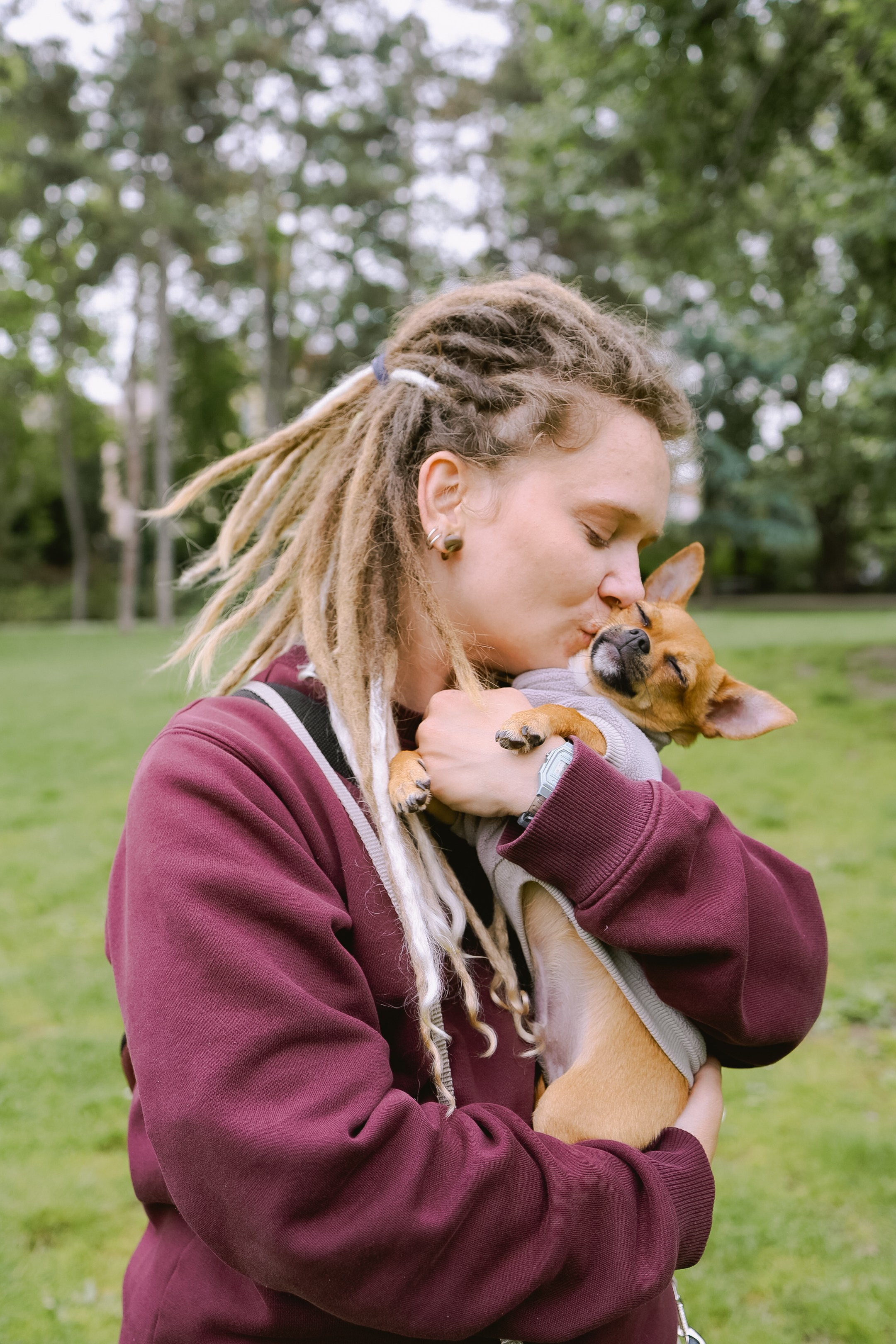 Юля с любовью целует свою собаку Роки, а он улыбается.