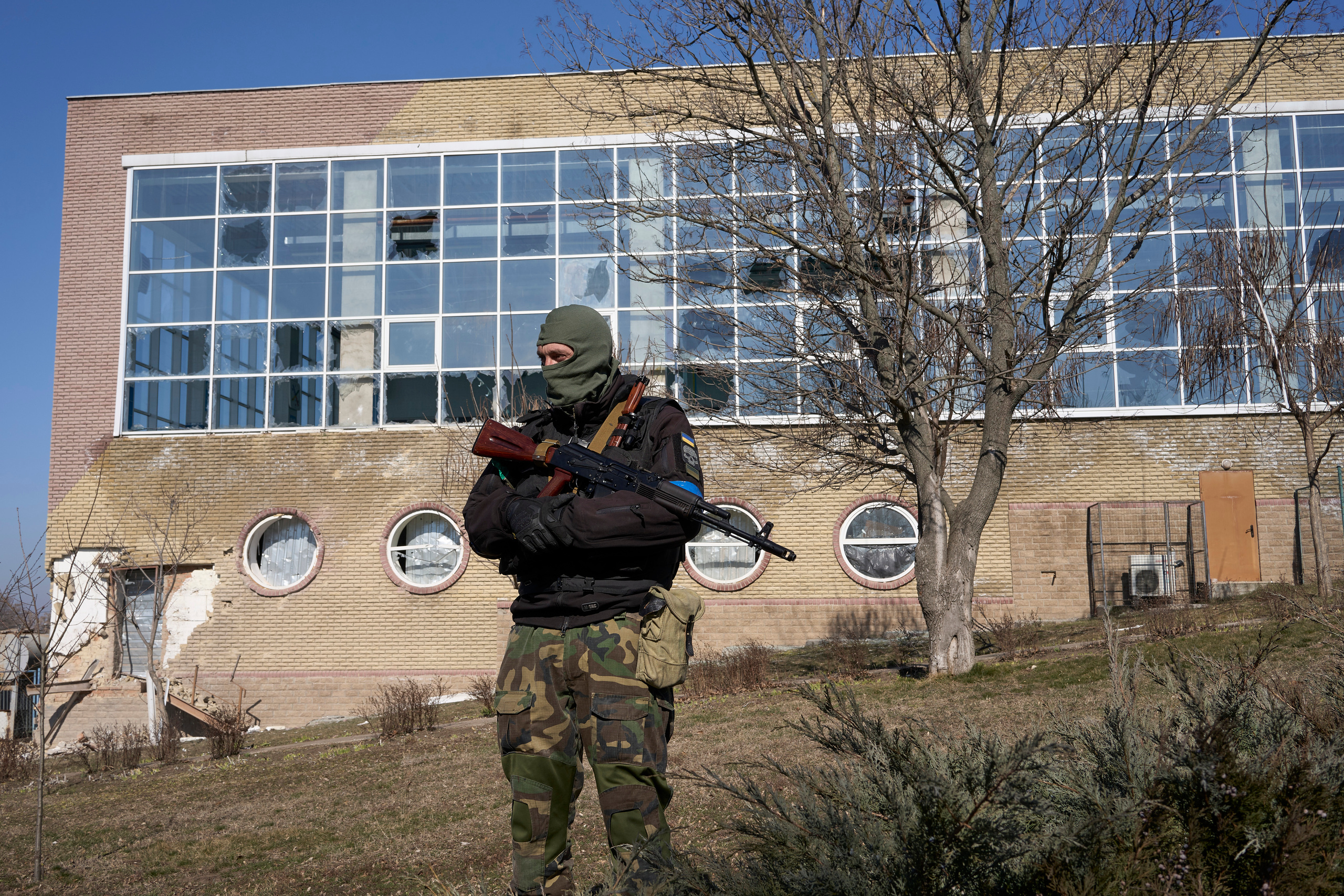 Ukrainian soldier in front of the bombed kids' swimming pool in the center of Voznesensk.