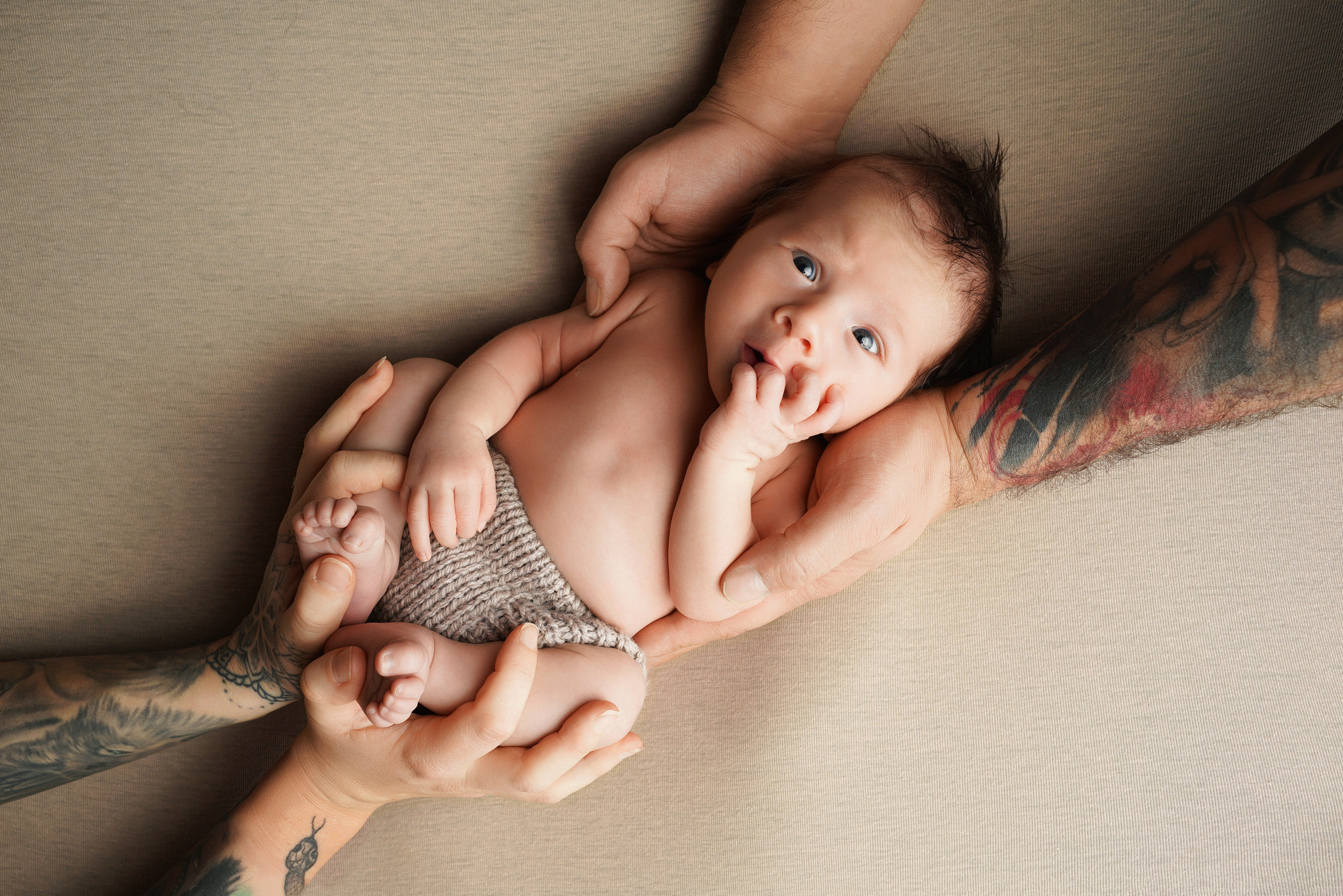 Detailaufnahme von kleinen Babyfüßchen in den Händen der Eltern – Babyfotografie Augsburg