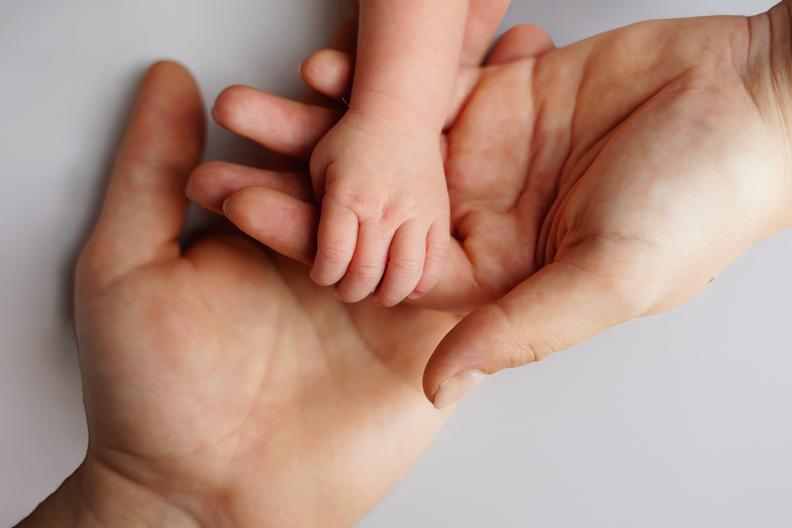 Glückliche Eltern halten ihr neugeborenes Baby im Arm – Familienshooting Augsburg