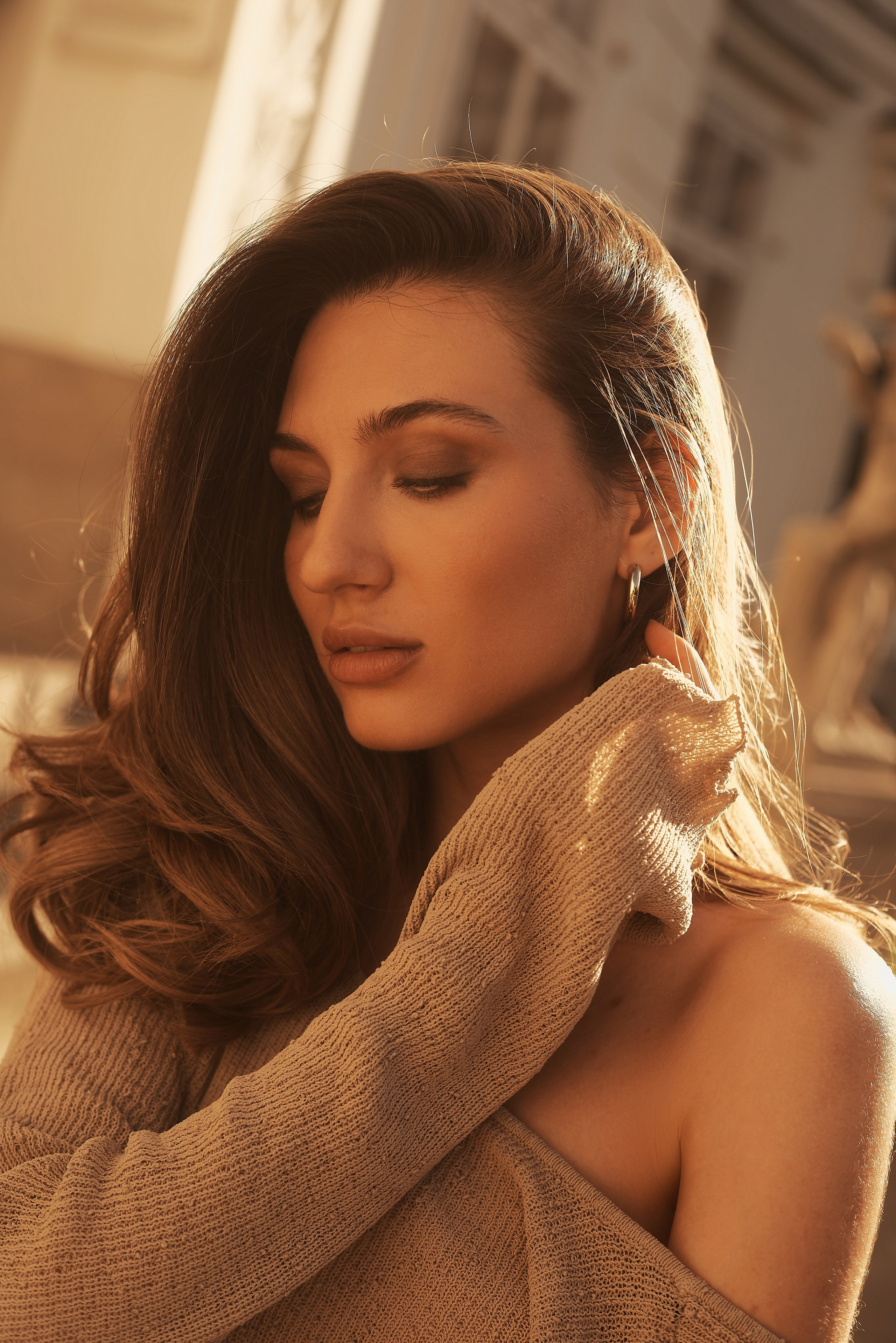 Крупний портрет жінки із закритими очима, її риси обличчя підкреслені сонячним світлом.