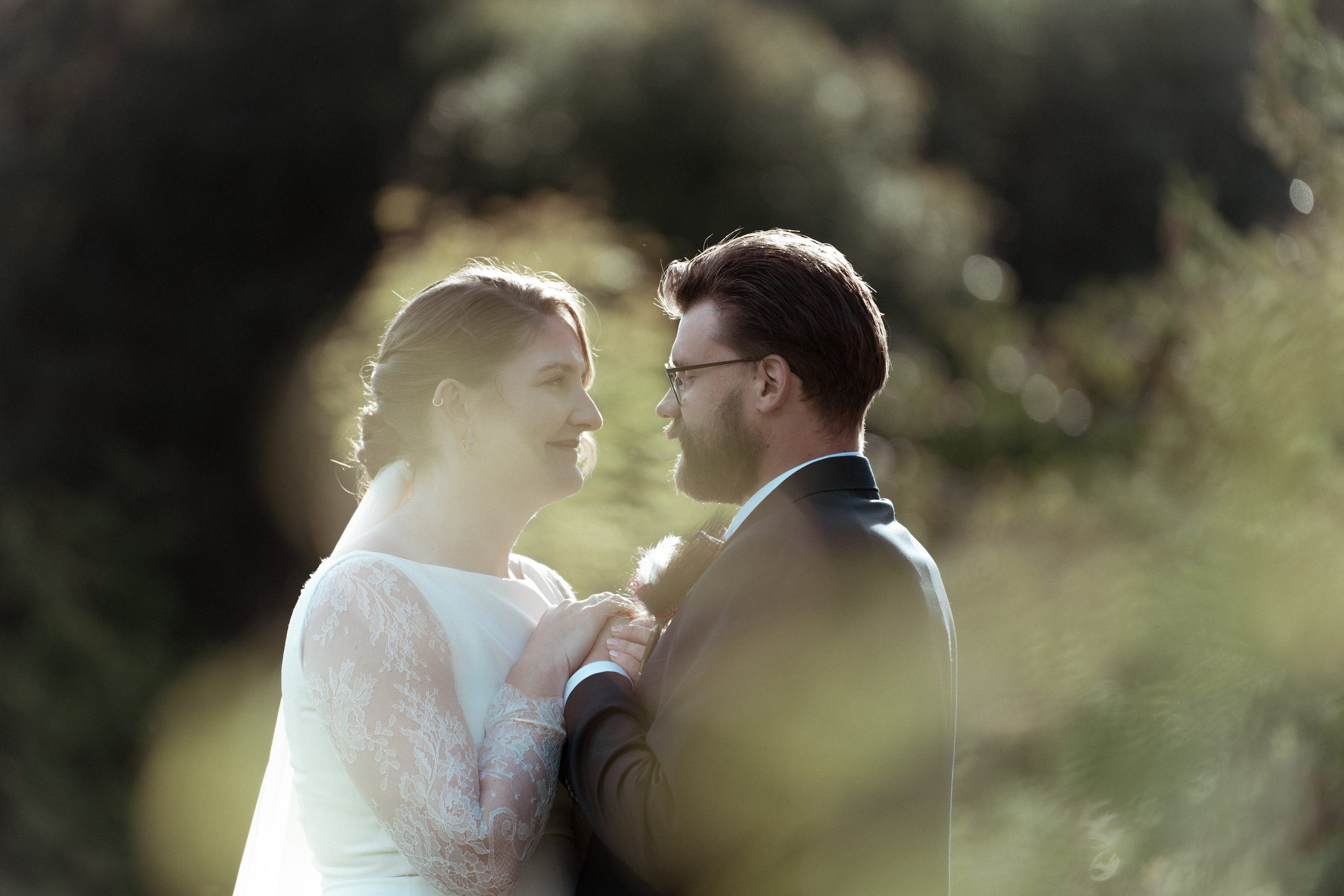 Det vakre brudeparet står ved siden av hverandre og ser på hverandre en sensommerdag