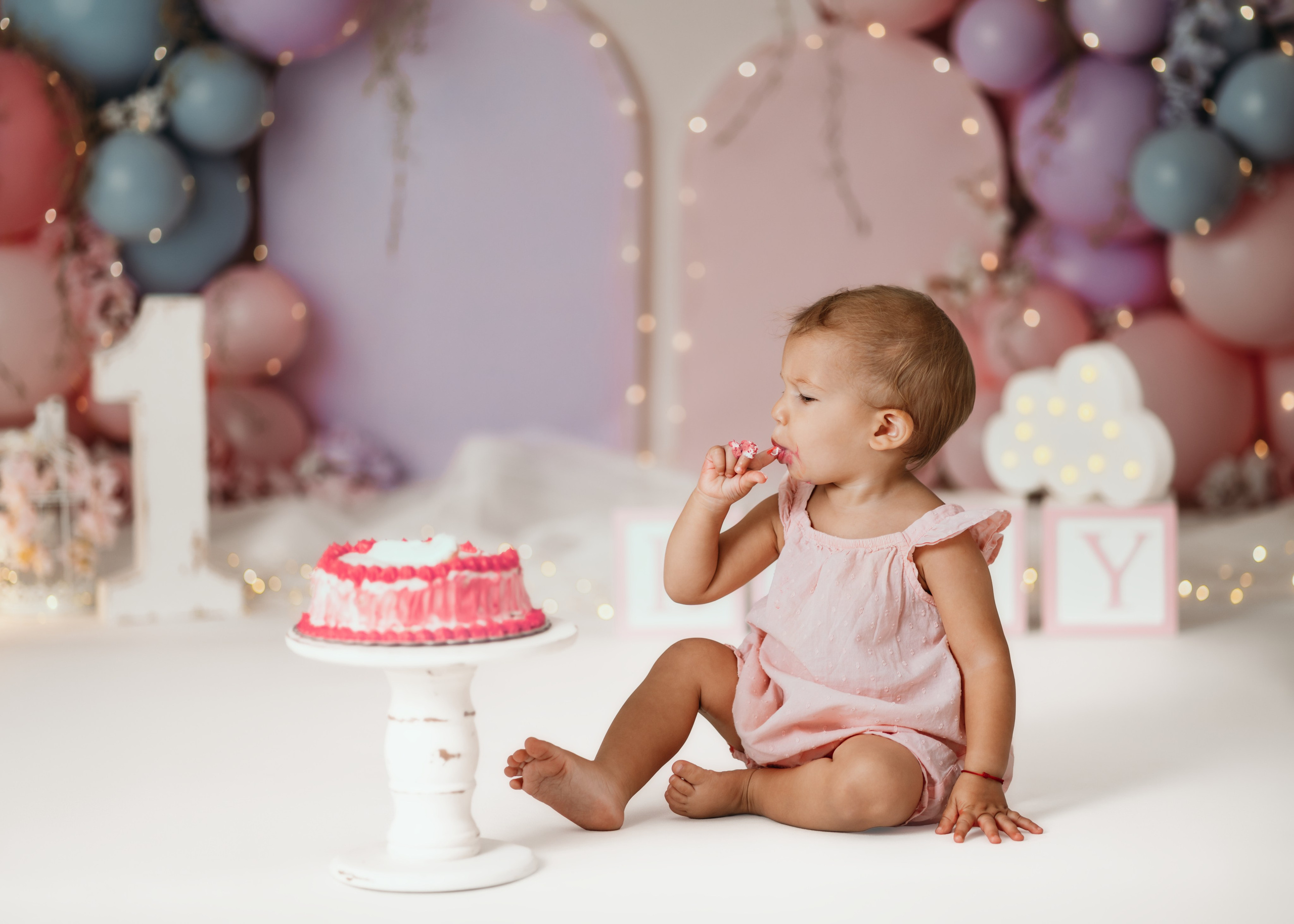 Beba u pastelnoj scenografiji tokom fotografisanja prvog rođendana