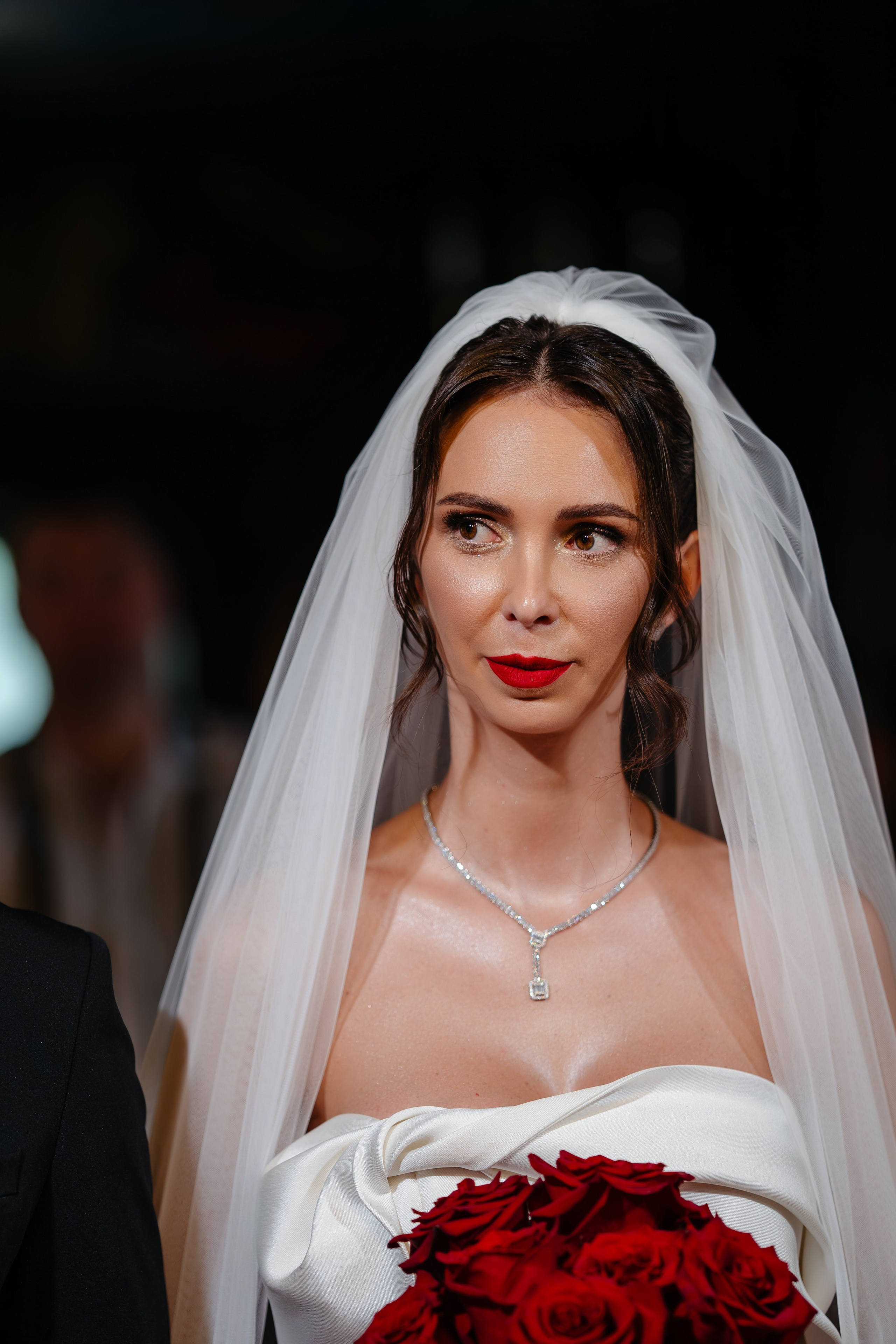 Plan apropiat cu mireasa Anca în biserică, purtând un voal lung și fin.