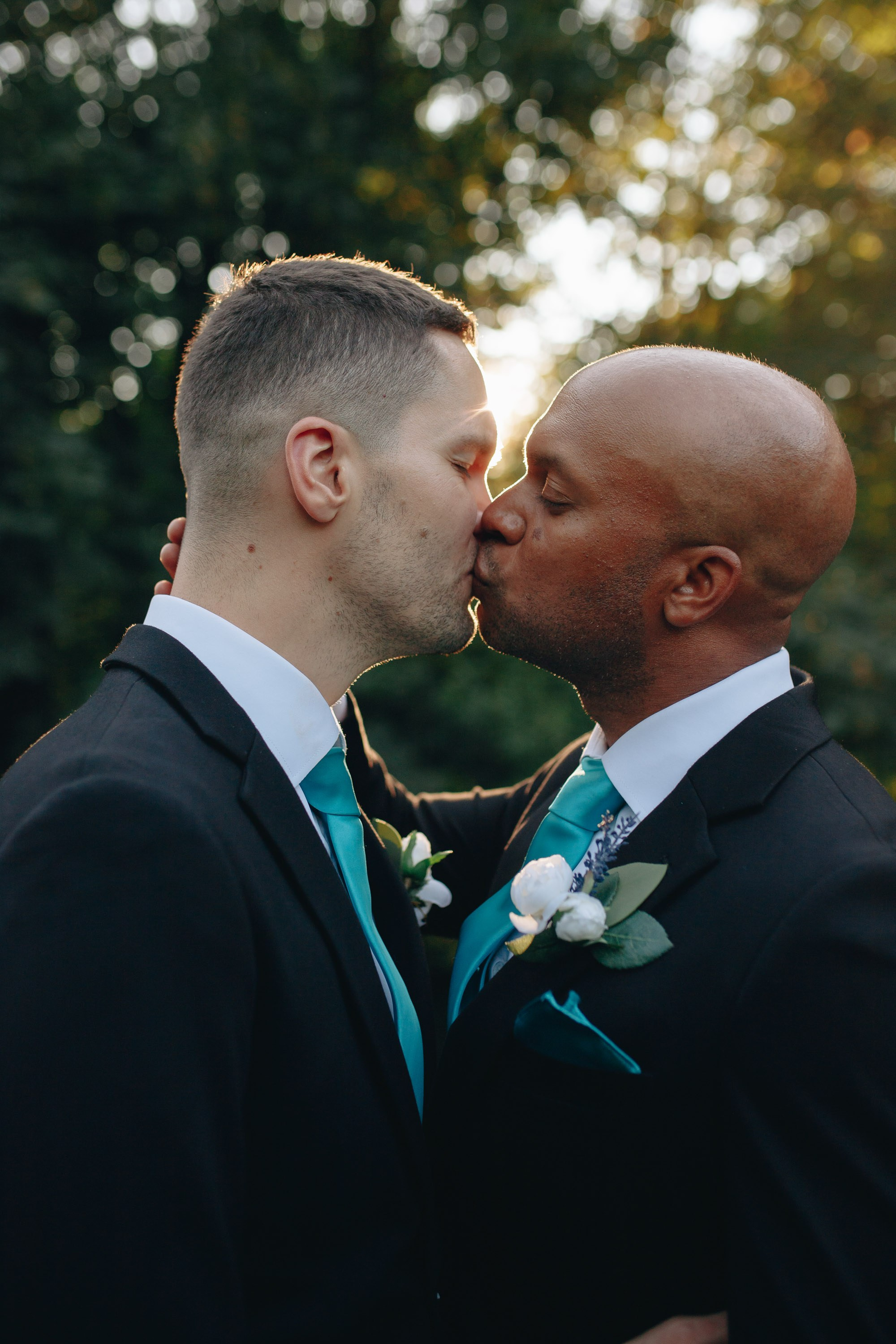 LGBTQ+ grooms kissing at wedding
