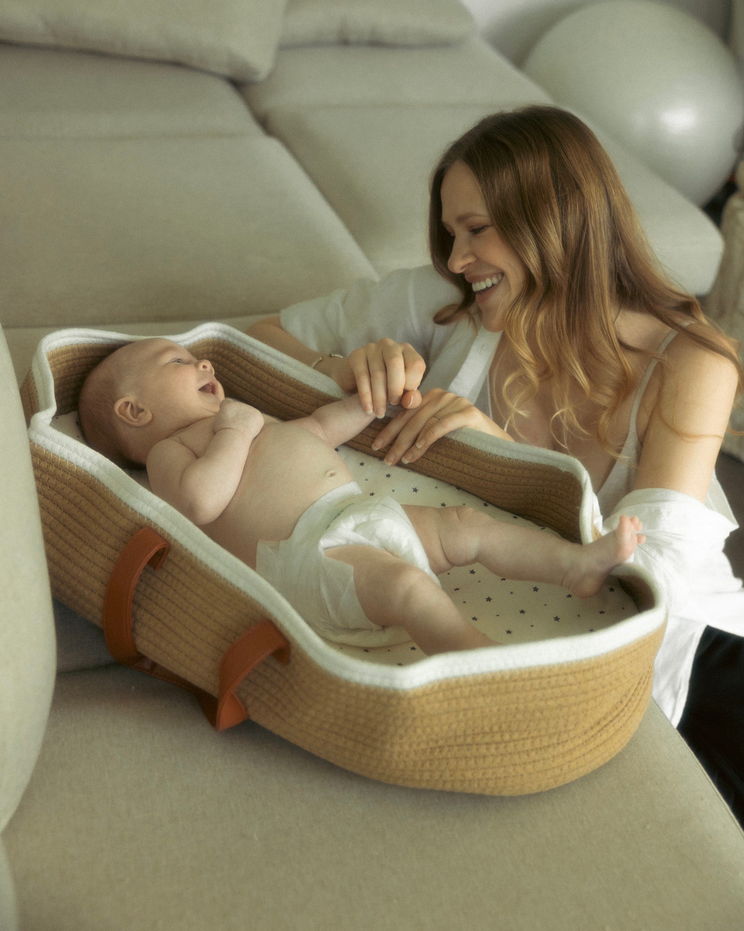 Mother laughing with her child during a candid family moment in a bright studio