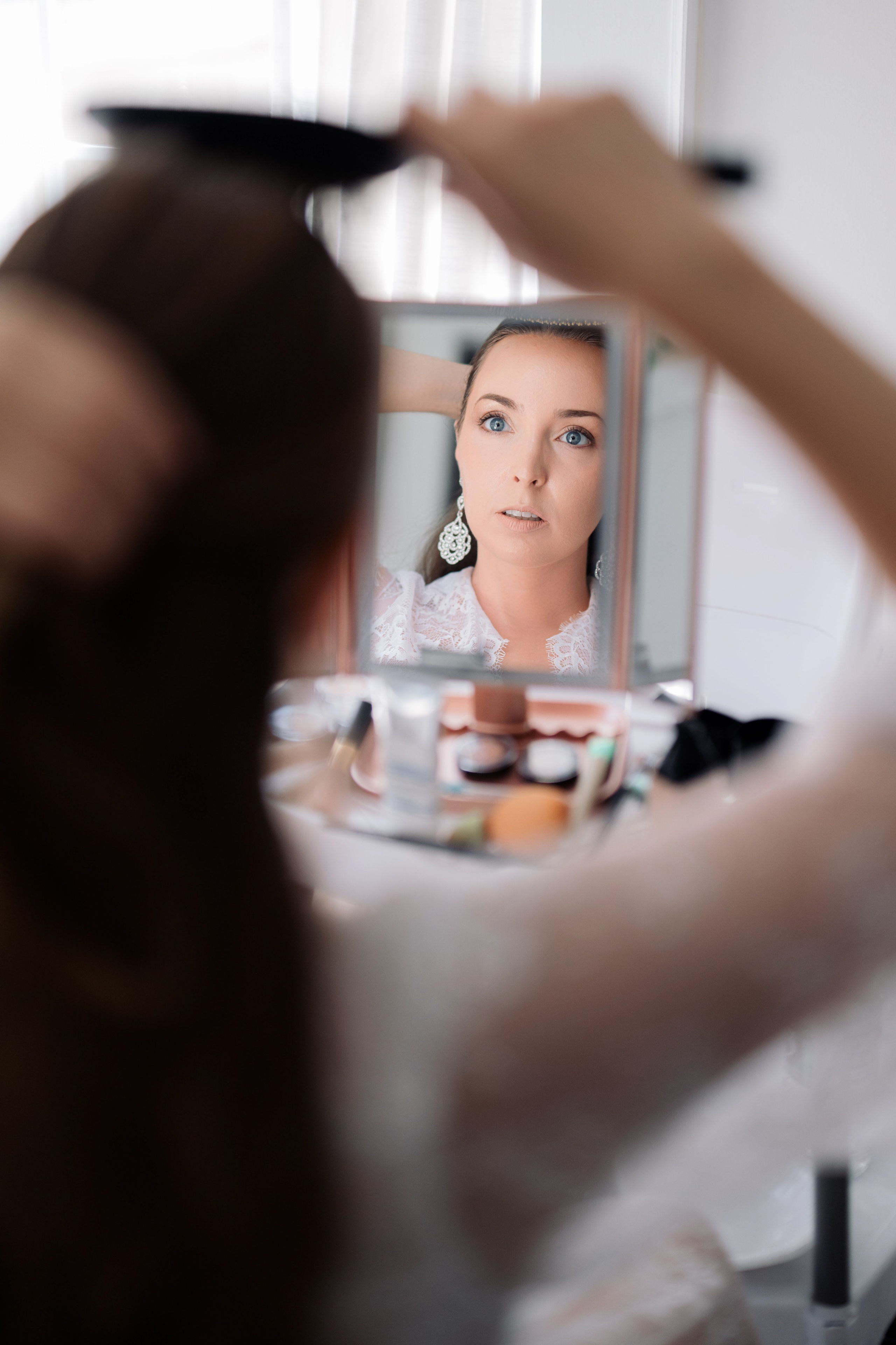 a woman is looking in the mirror