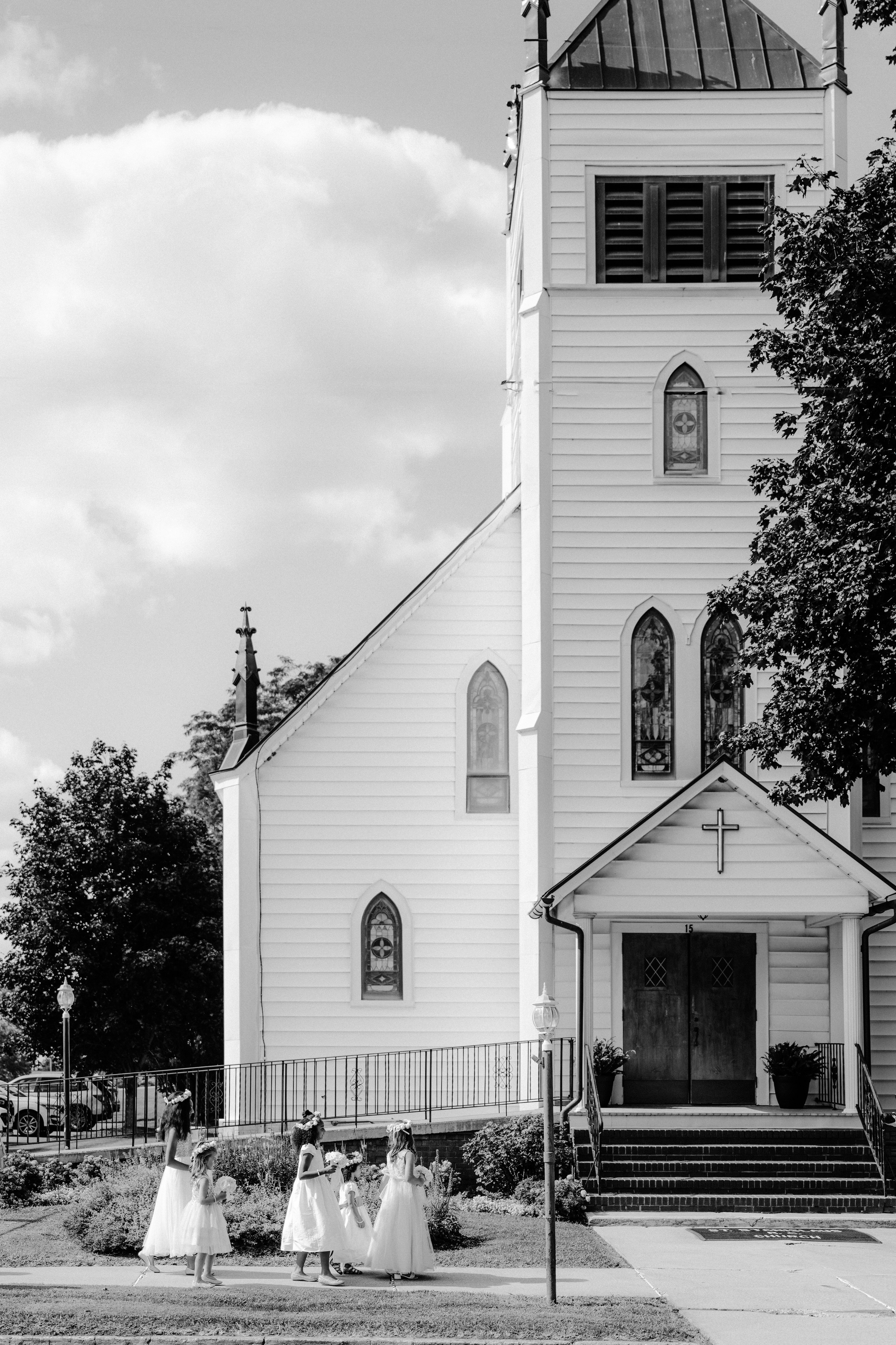 a bride and groom walking towards the church