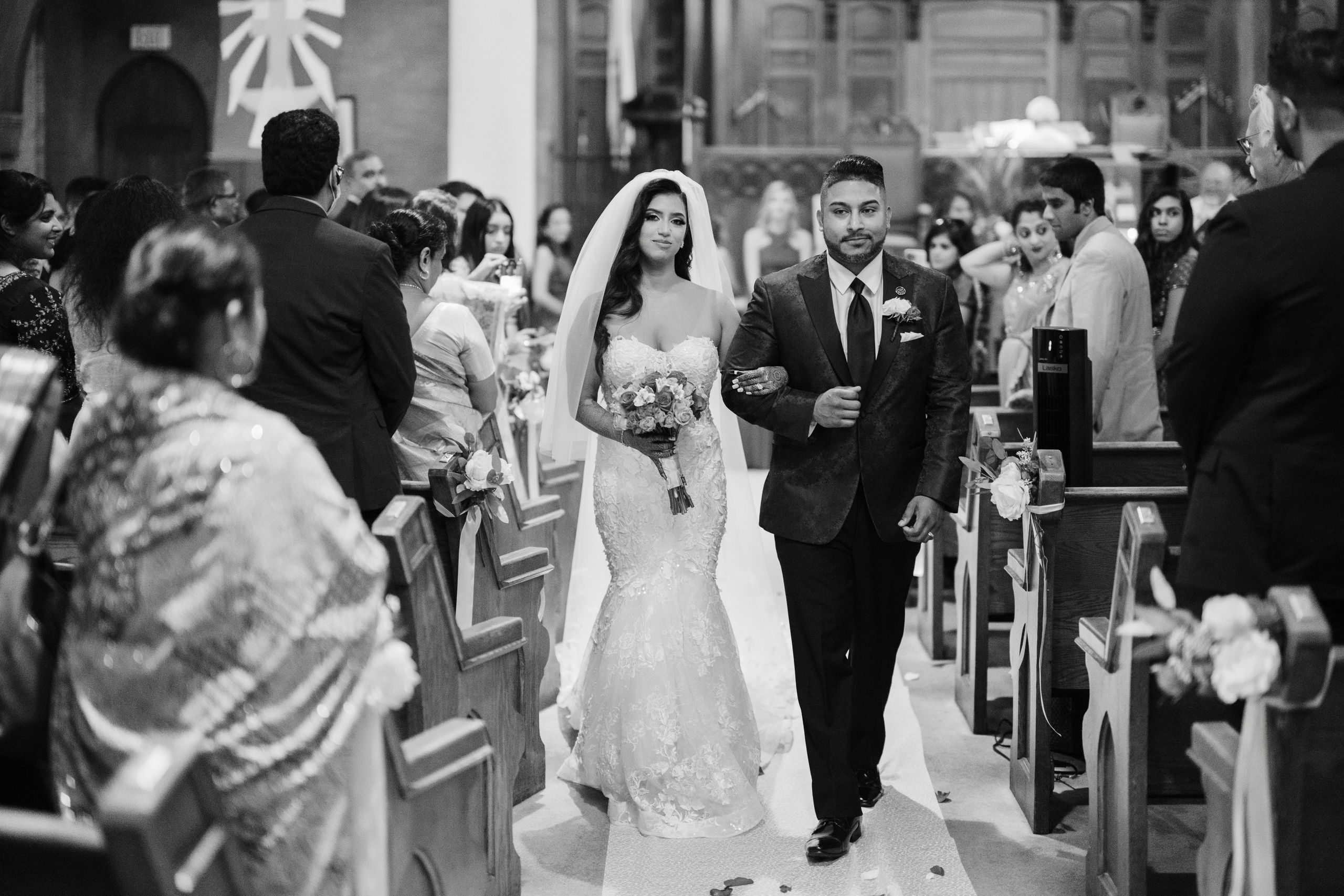 a bride and groom walking down the aisle