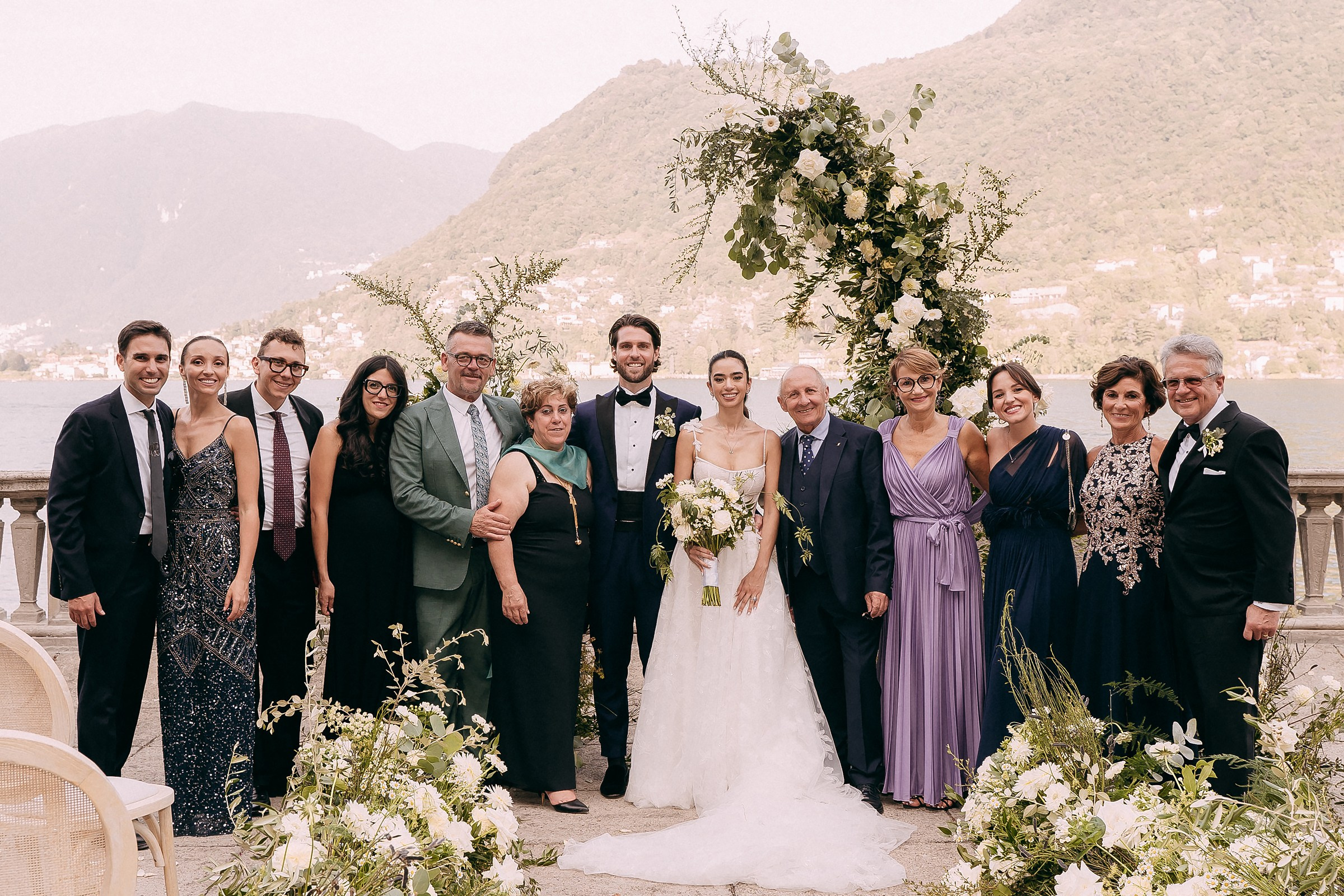 A group of people posing for the photo in festive wedding decorations.