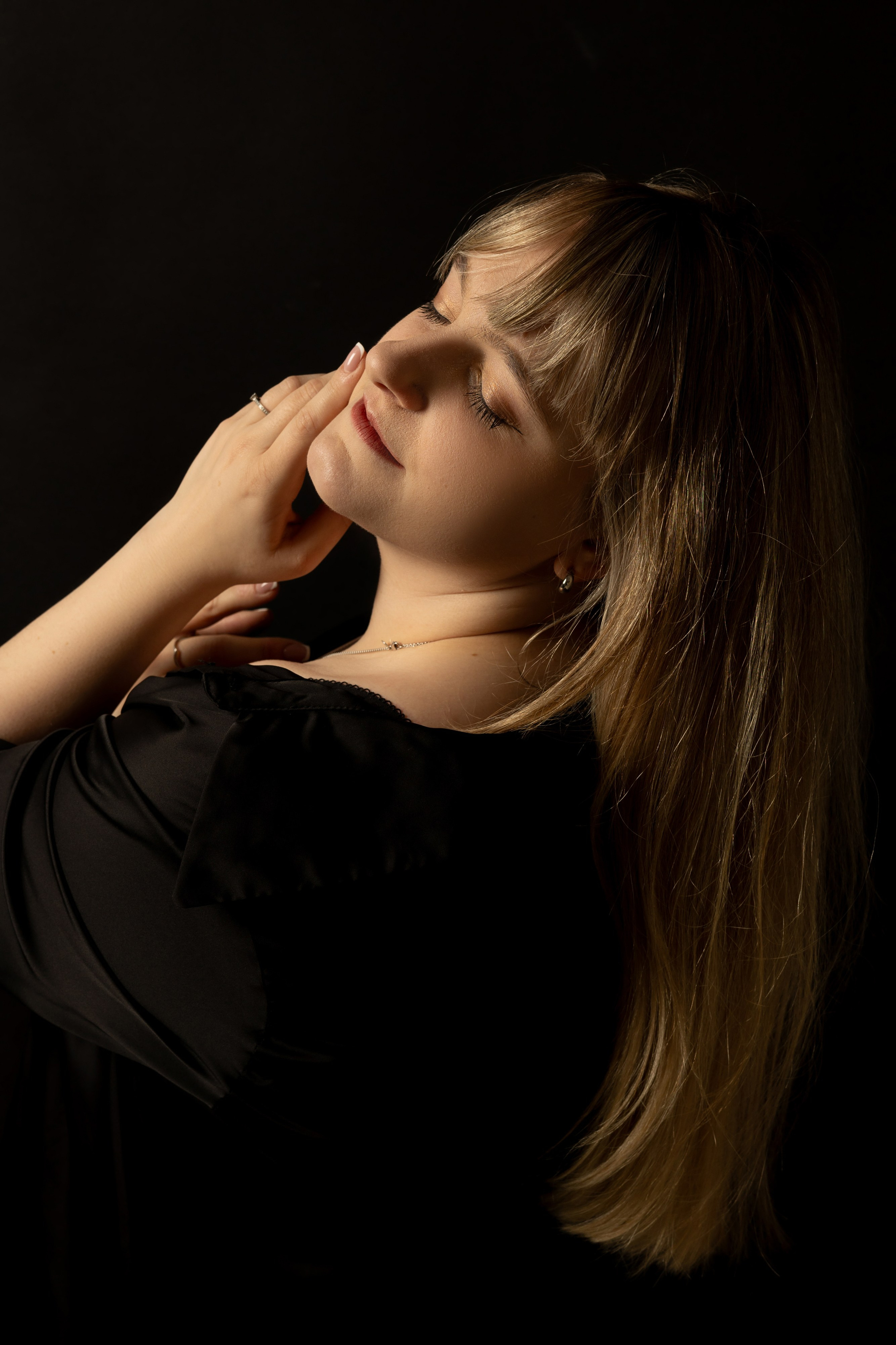 "Nahaufnahme einer Frau mit intensivem Blick, vor dunklem Hintergrund inszeniert."