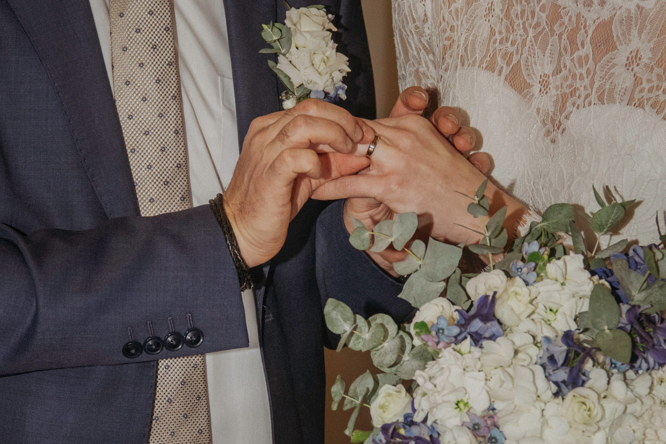 Le marié passe la bague de mariage au doigt de la mariée.