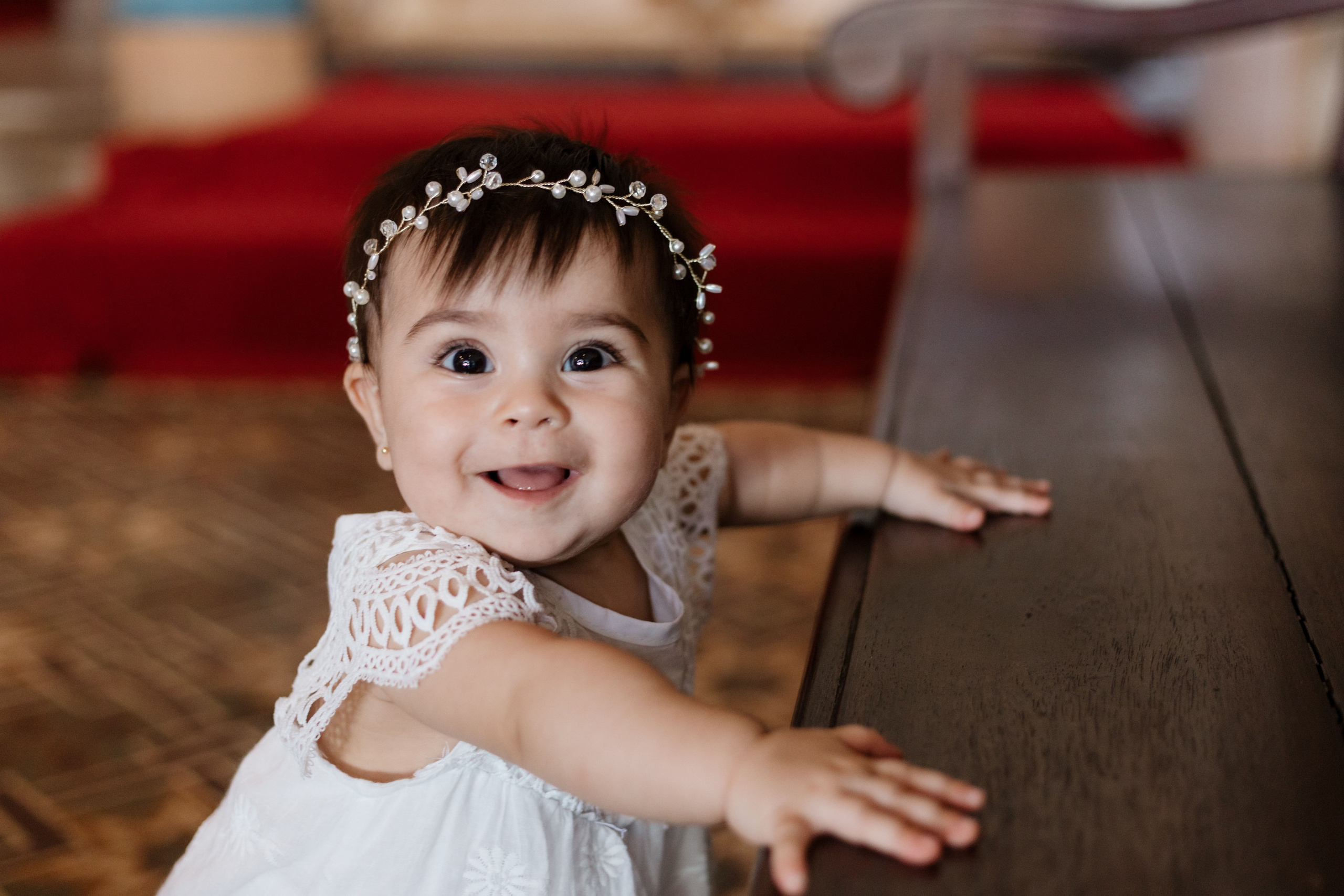 Menina sorrindo em igreja, antes do batizado