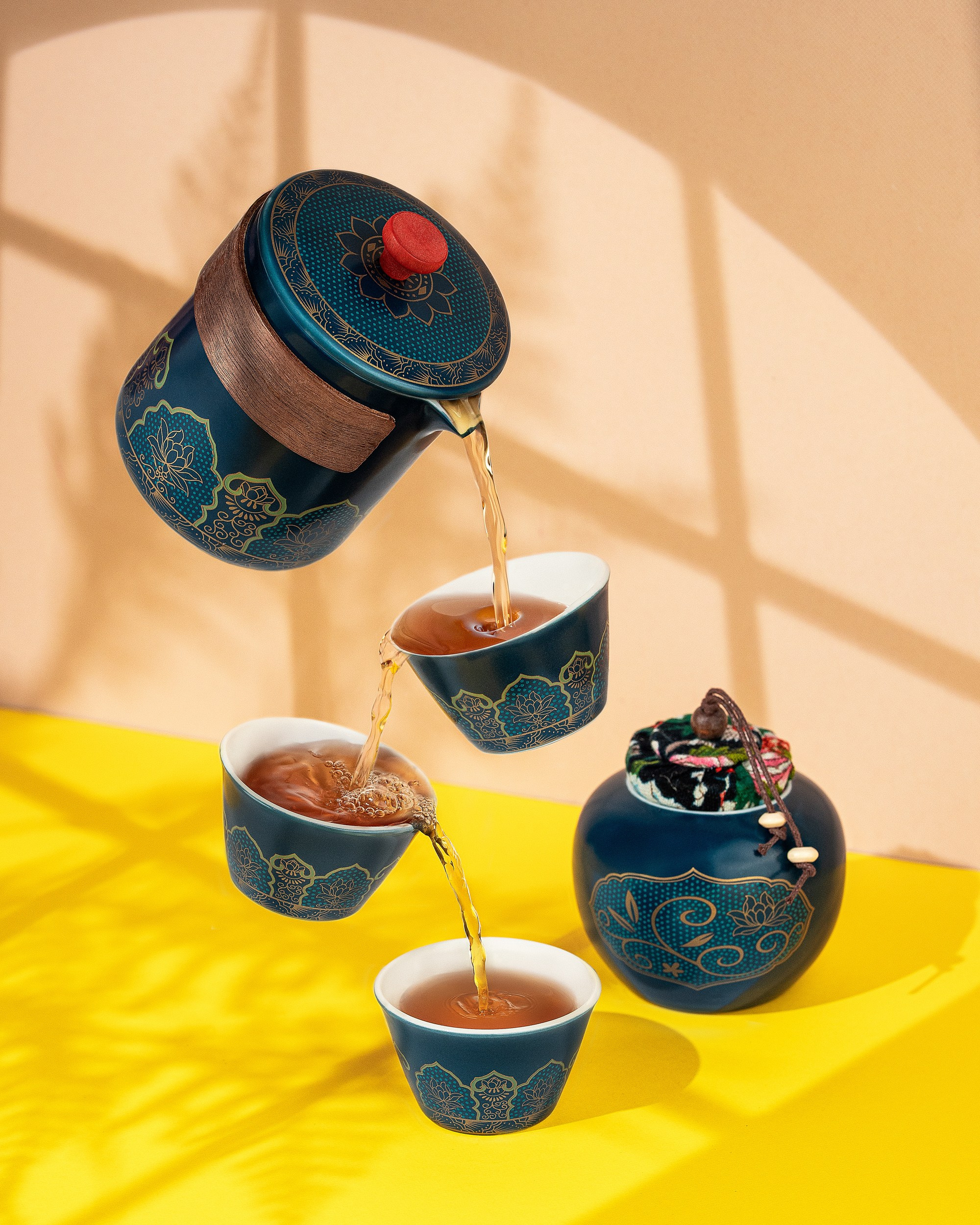 Surreal Chinese teapot pouring tea into floating cups on yellow background, surreal tea photo