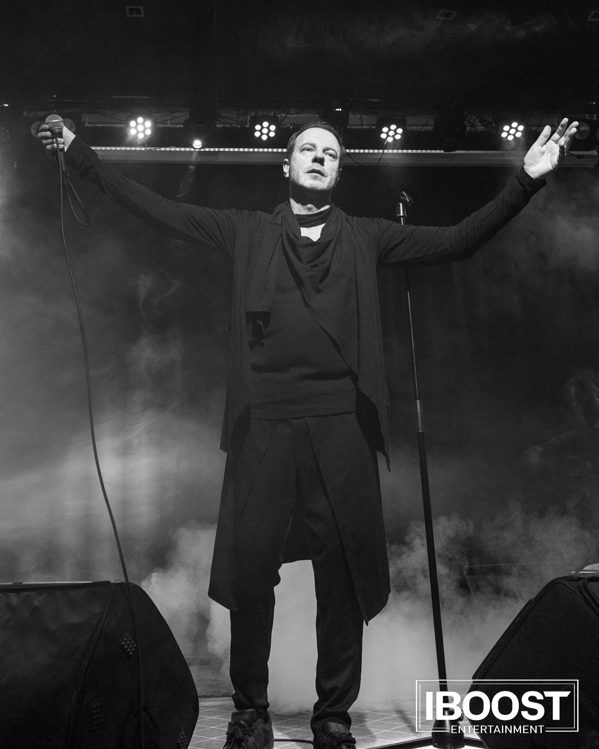 Black-and-white full-length photo of vocalist Krasovitsky performing on stage with both arms outstretched during the Animal JazZ concert in Sofia.