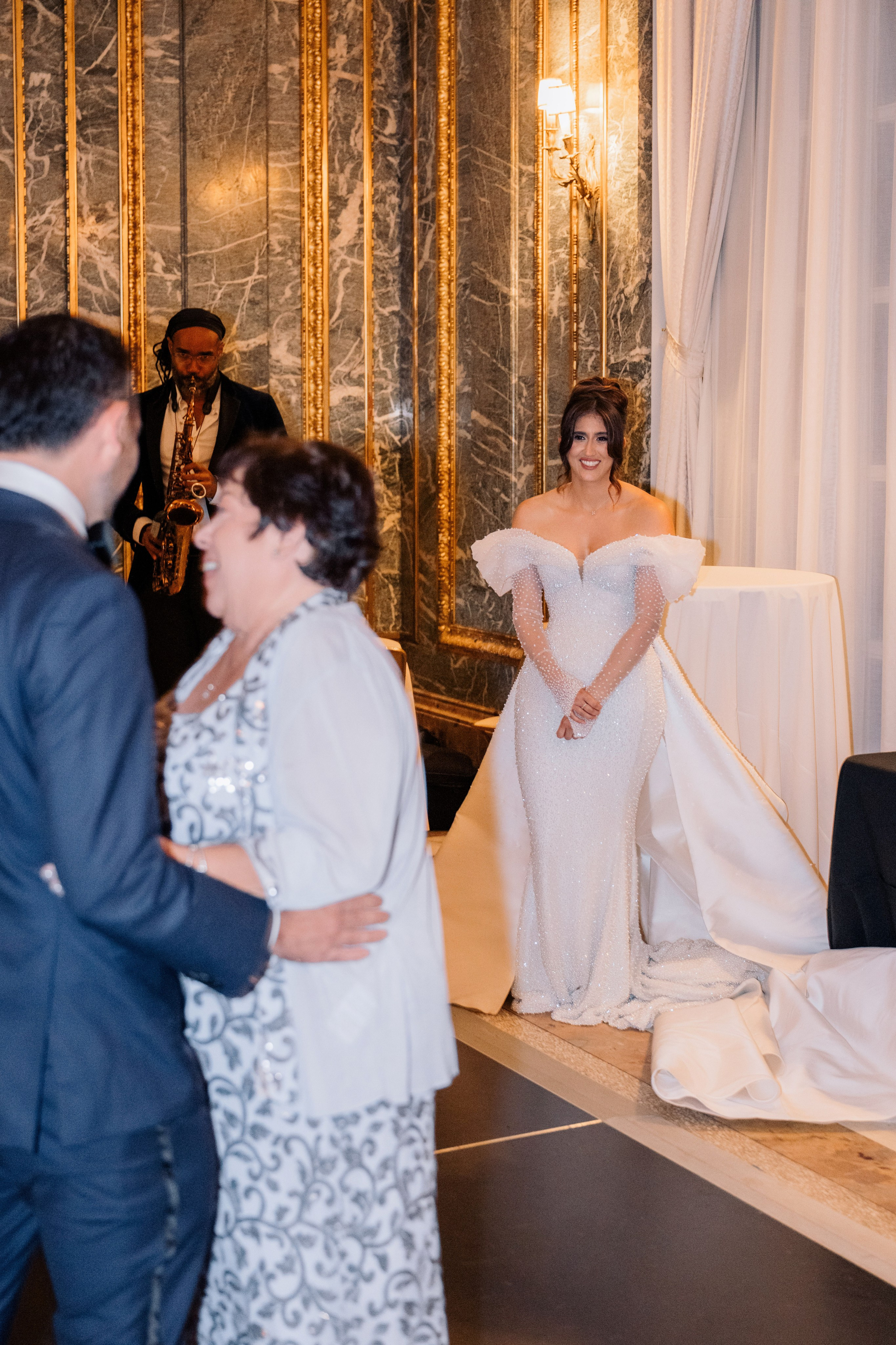 a woman in a white dress is standing next to a man in a suit