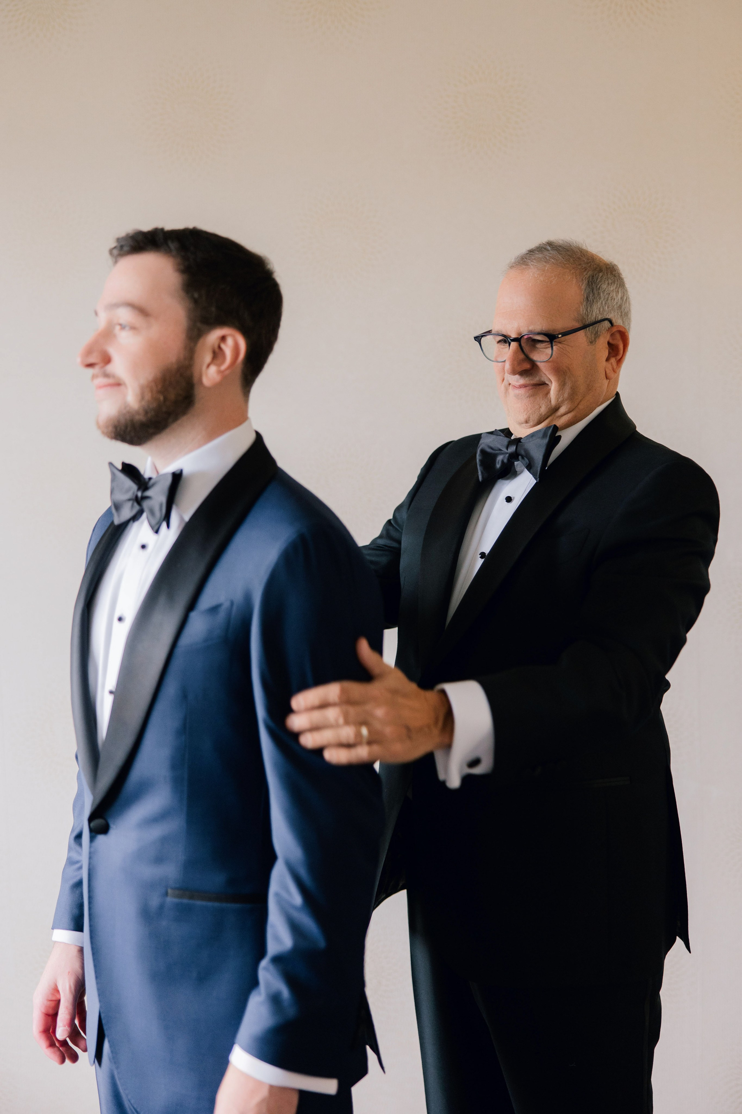 two men in suits and bow ties are standing