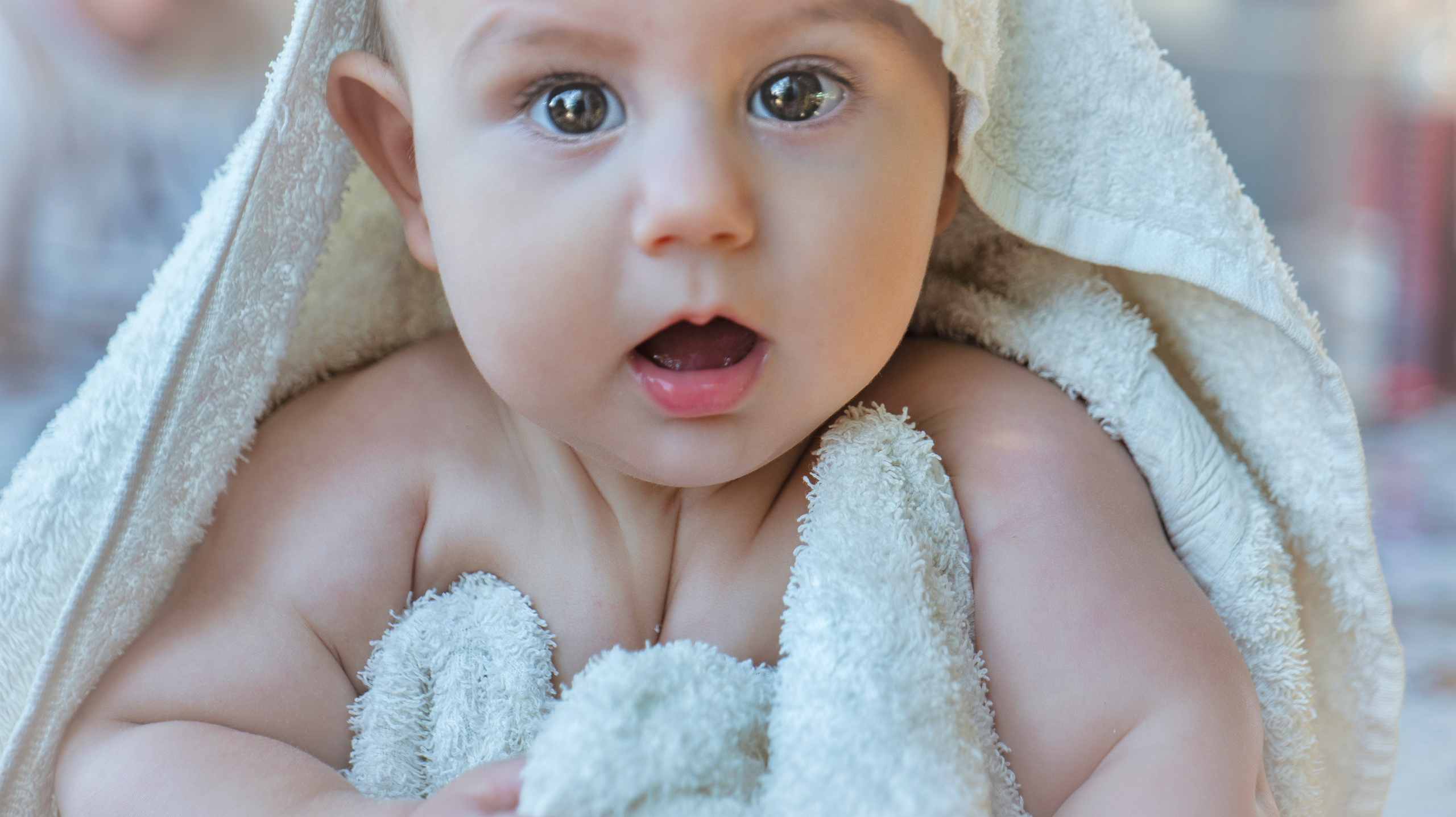 Bebé envuelto en una toalla blanca después del baño.