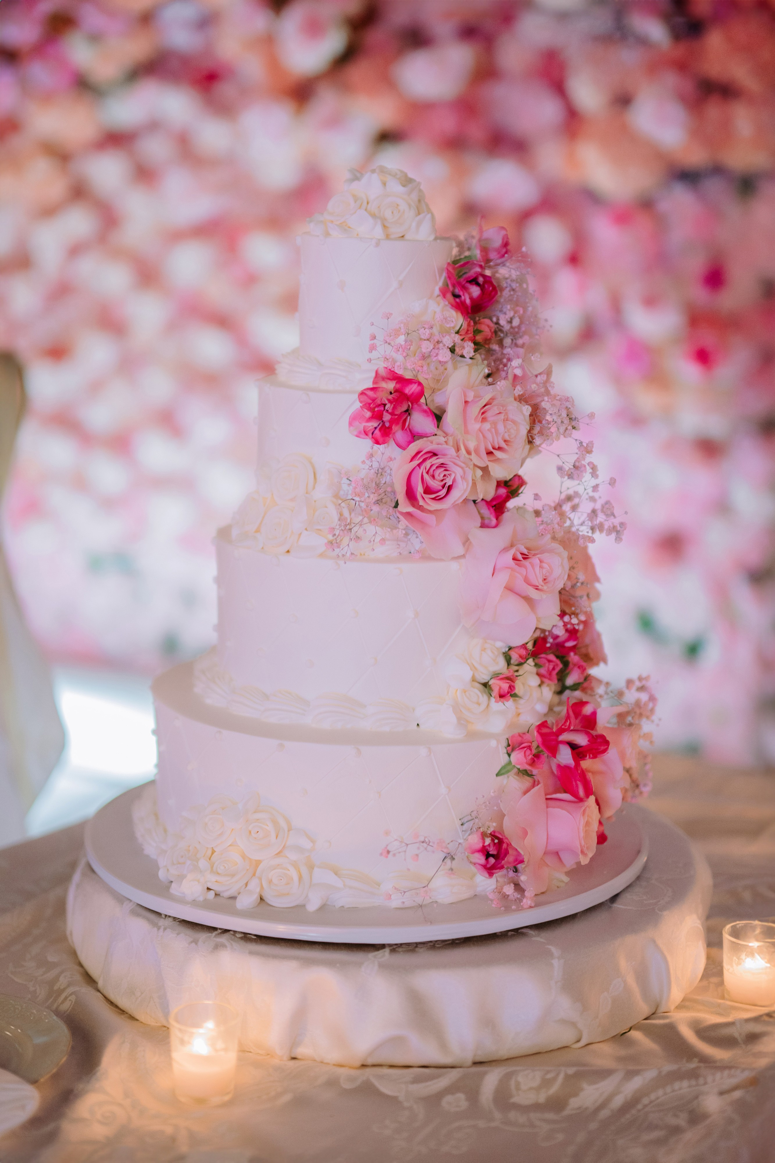 a white wedding cake with pink flowers on top