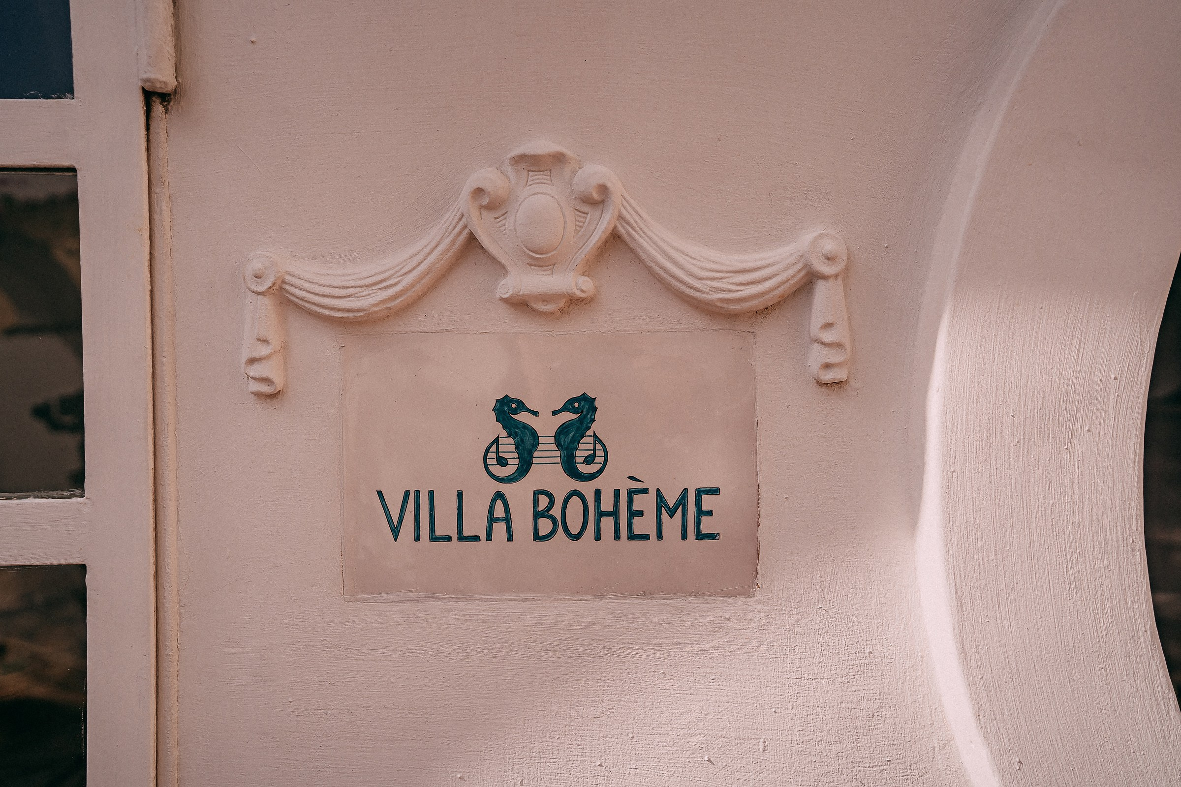 The charming “Villa Bohème” sign featuring decorative sea horse illustrations, beautifully displayed on an elegant wall.