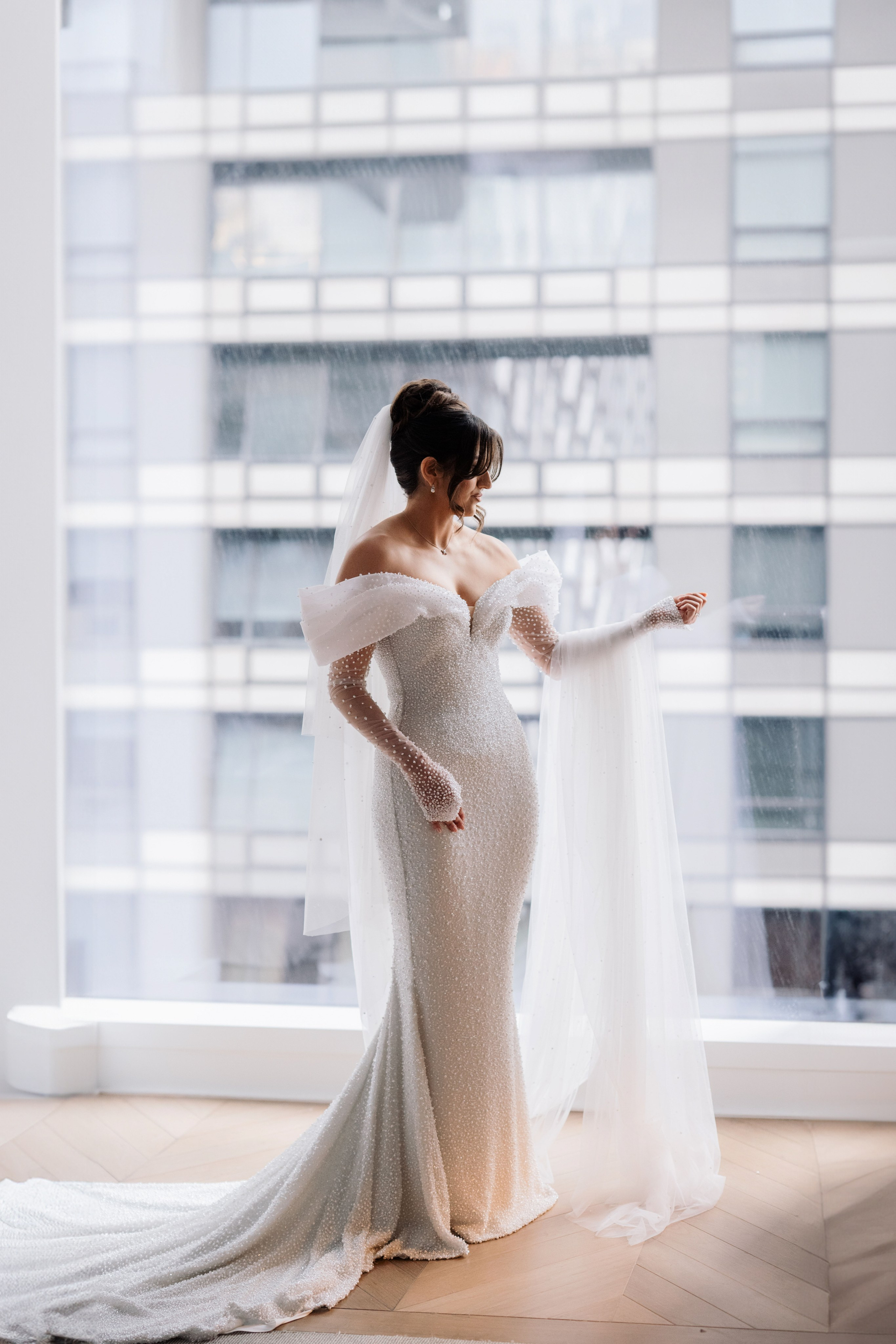 a woman in a wedding dress looking out a window