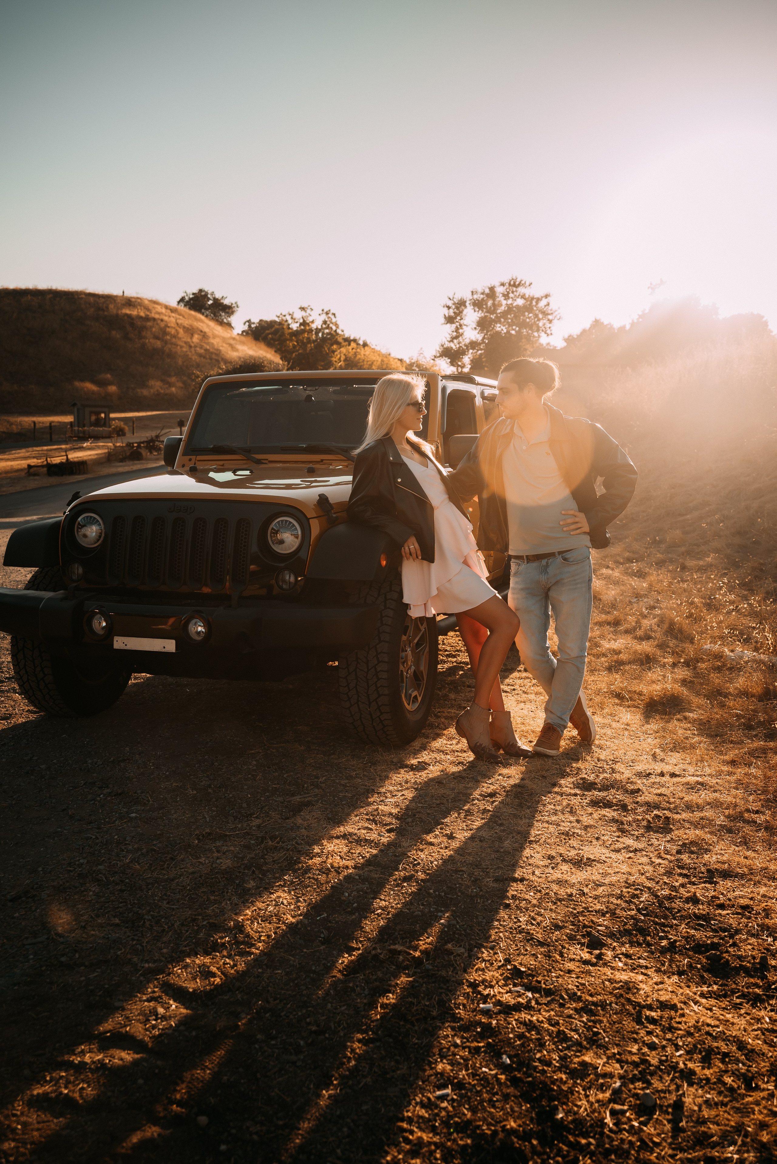 The couple joyfully poses by rugged Jeep, intertwining adventure with a love story.