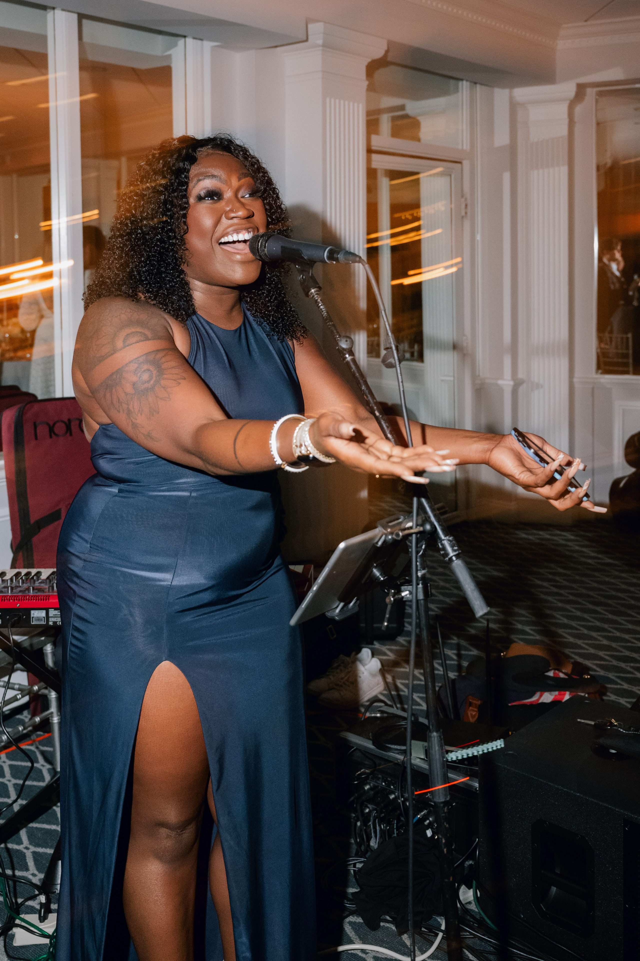 a woman in a blue dress singing into a microphone