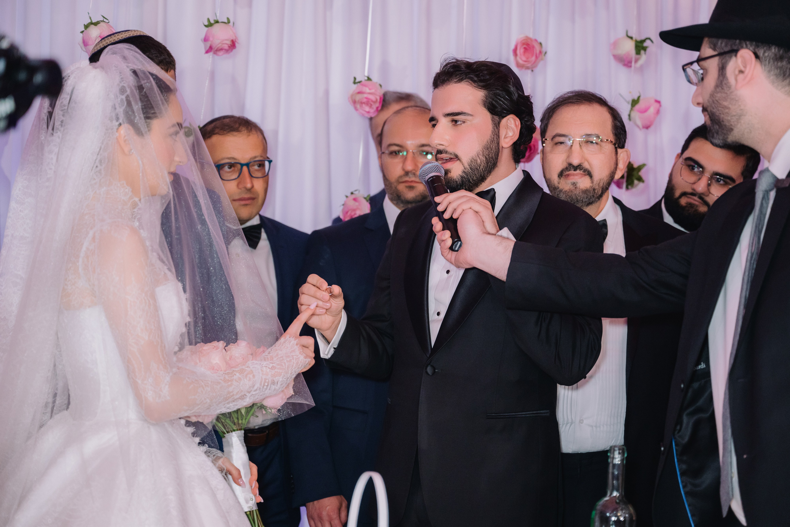 a man and woman are standing in front of a man in a suit