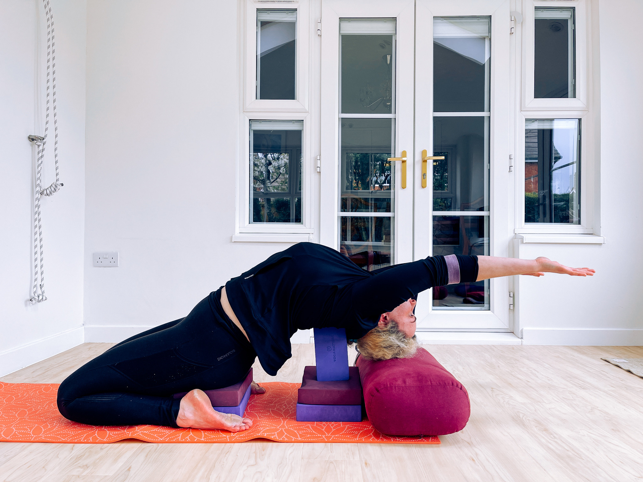 A girl in Paryankasana in Iyengar yoga studio.