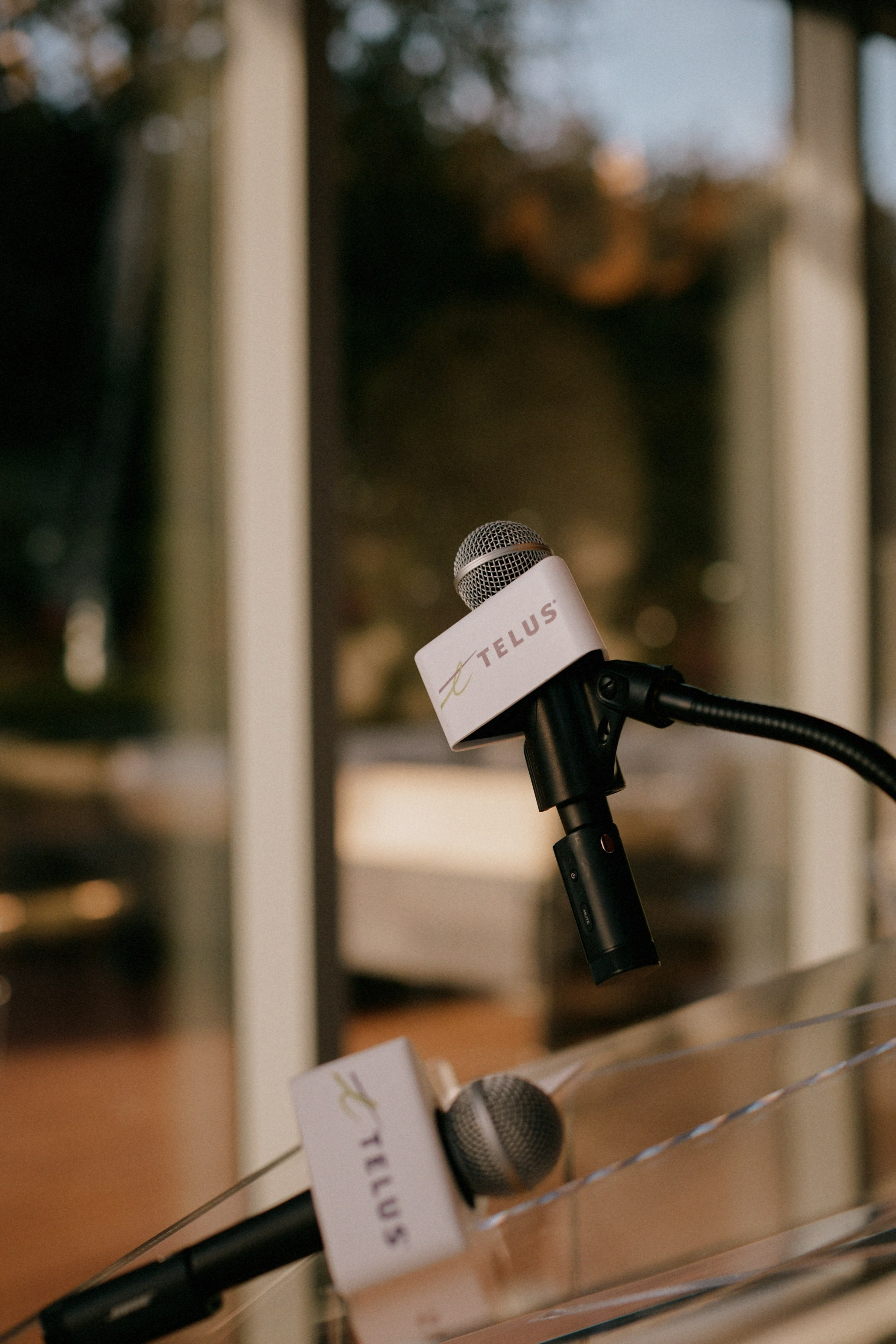 TELUS microphones on a clear lectern before The Career Curve panel, PayTech Women Vancouver