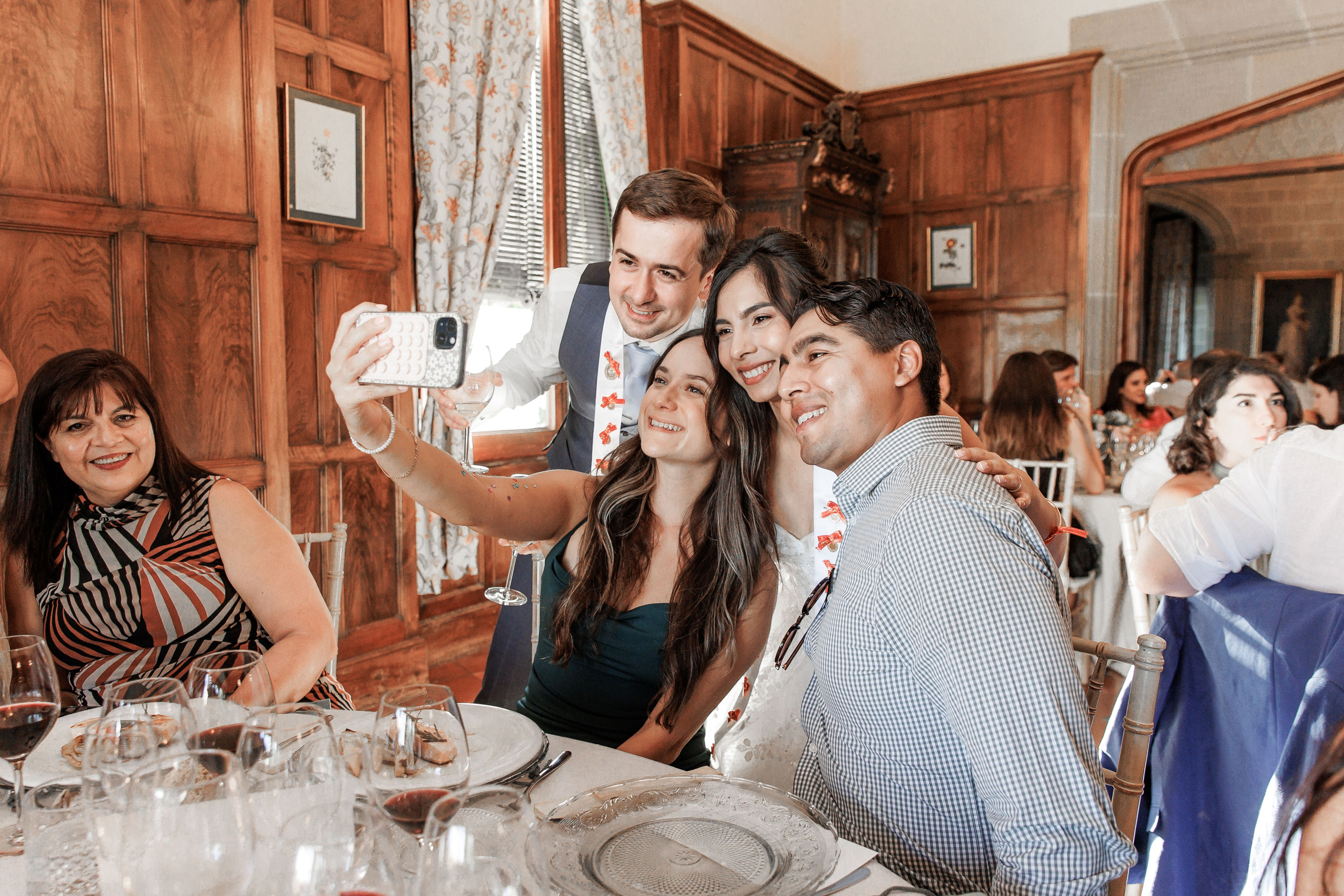 Wedding guests are capturing memories with their cameras during a beautiful outdoor ceremony in Barcelona.