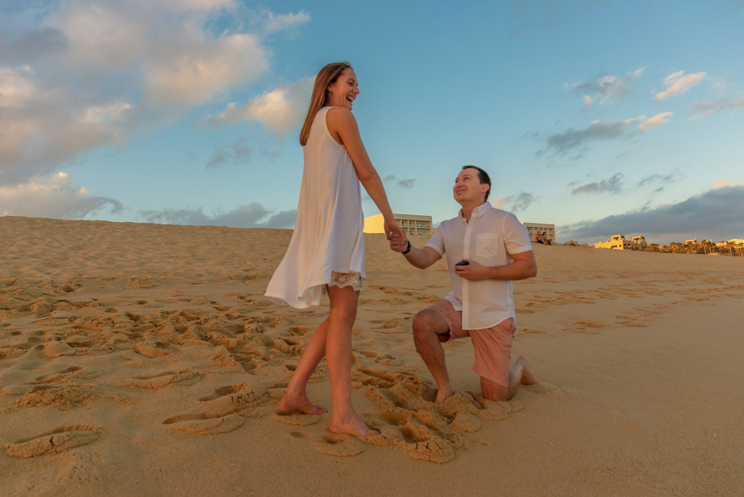 Man kneeling down to propose during couples photo session on beach Los Cabos