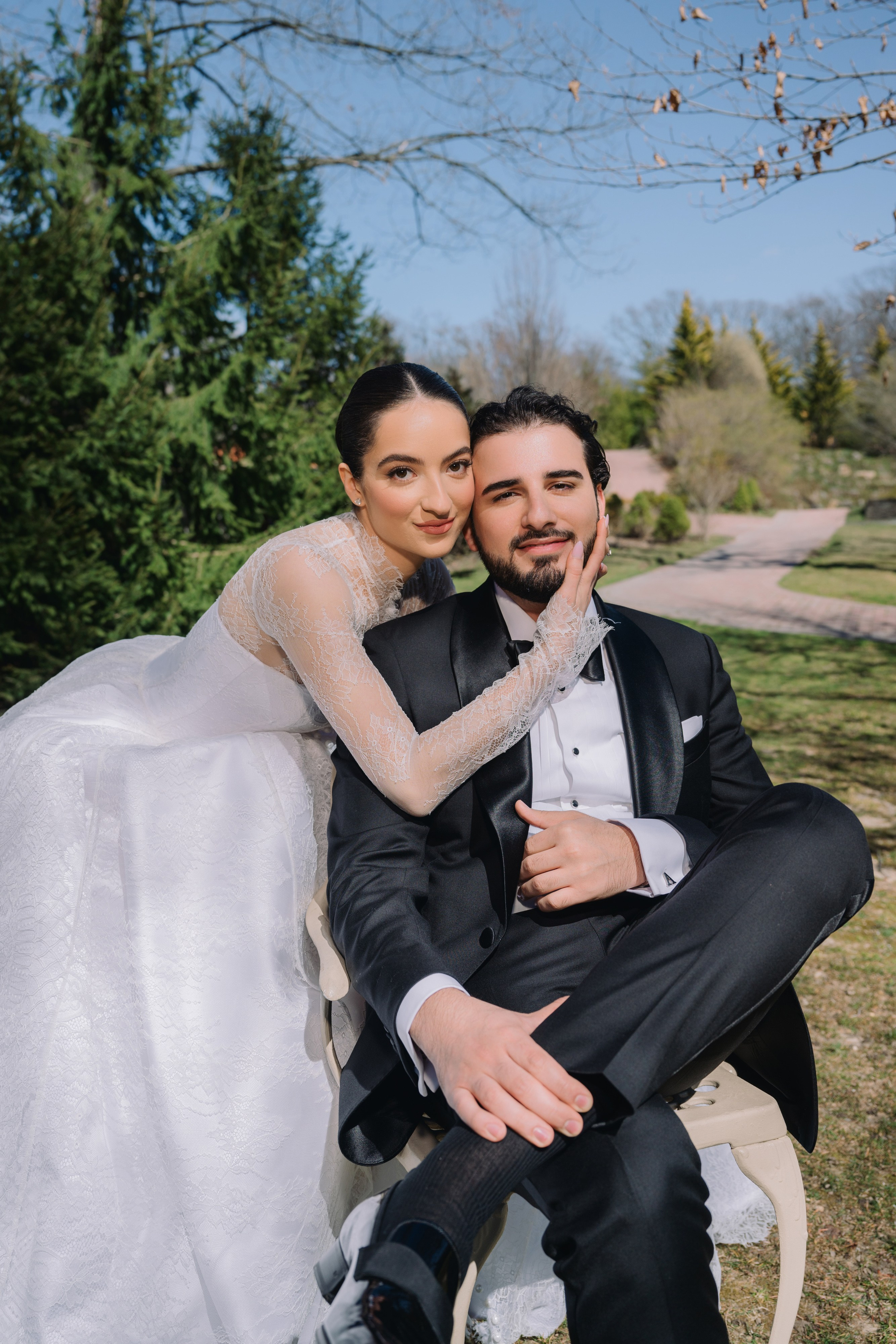 a bride and groom sitting on a bench