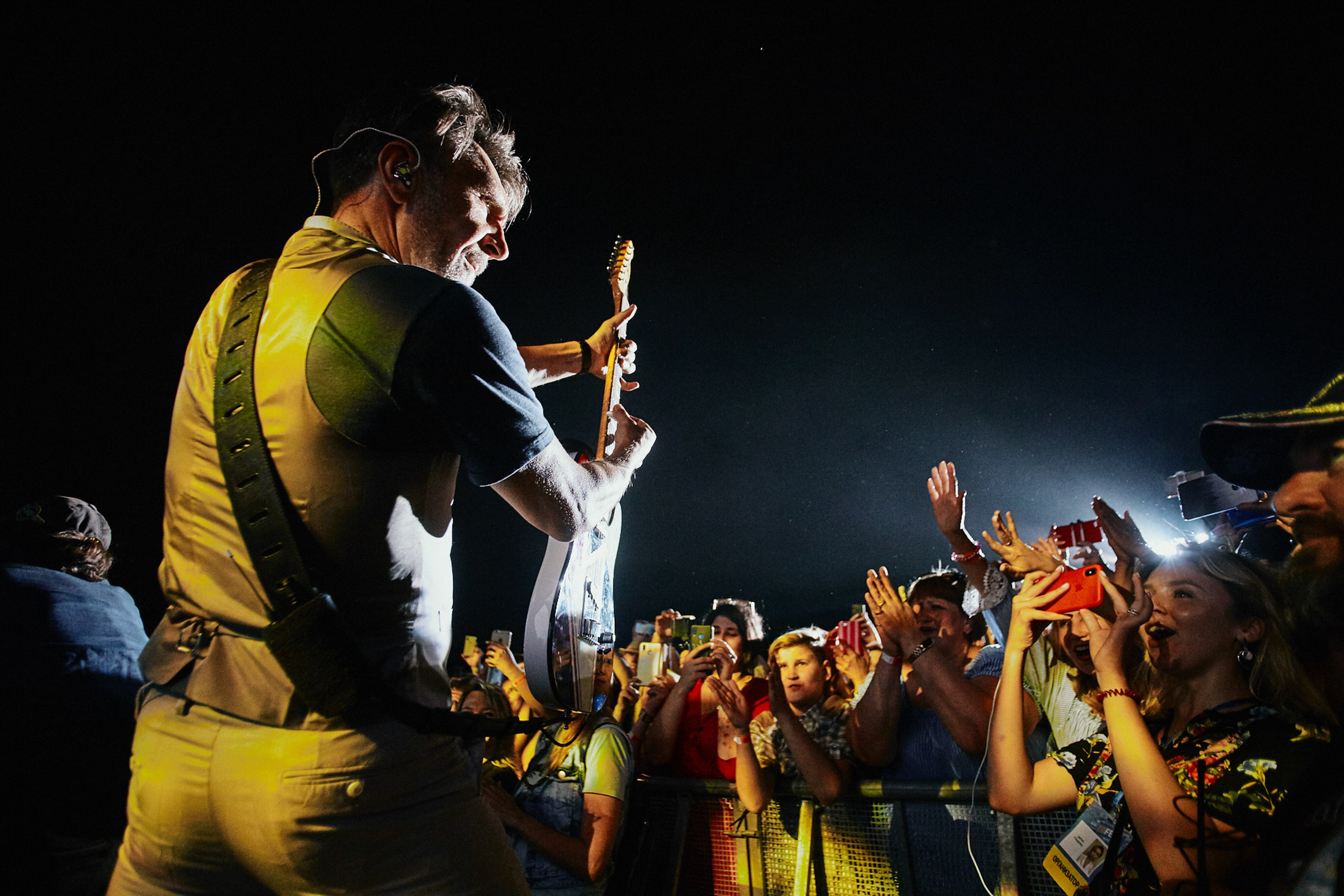 Singer performing at concert, live event photography