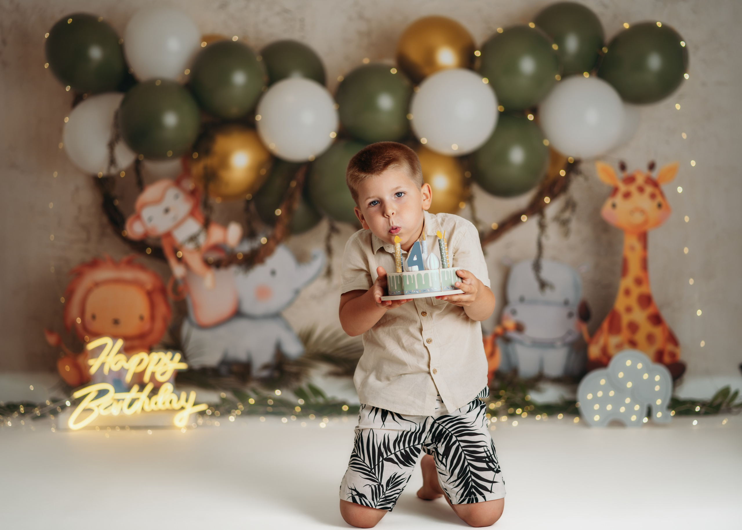 Fotografisanje prvog rođendana u džungla temi sa životinjama i lampicama