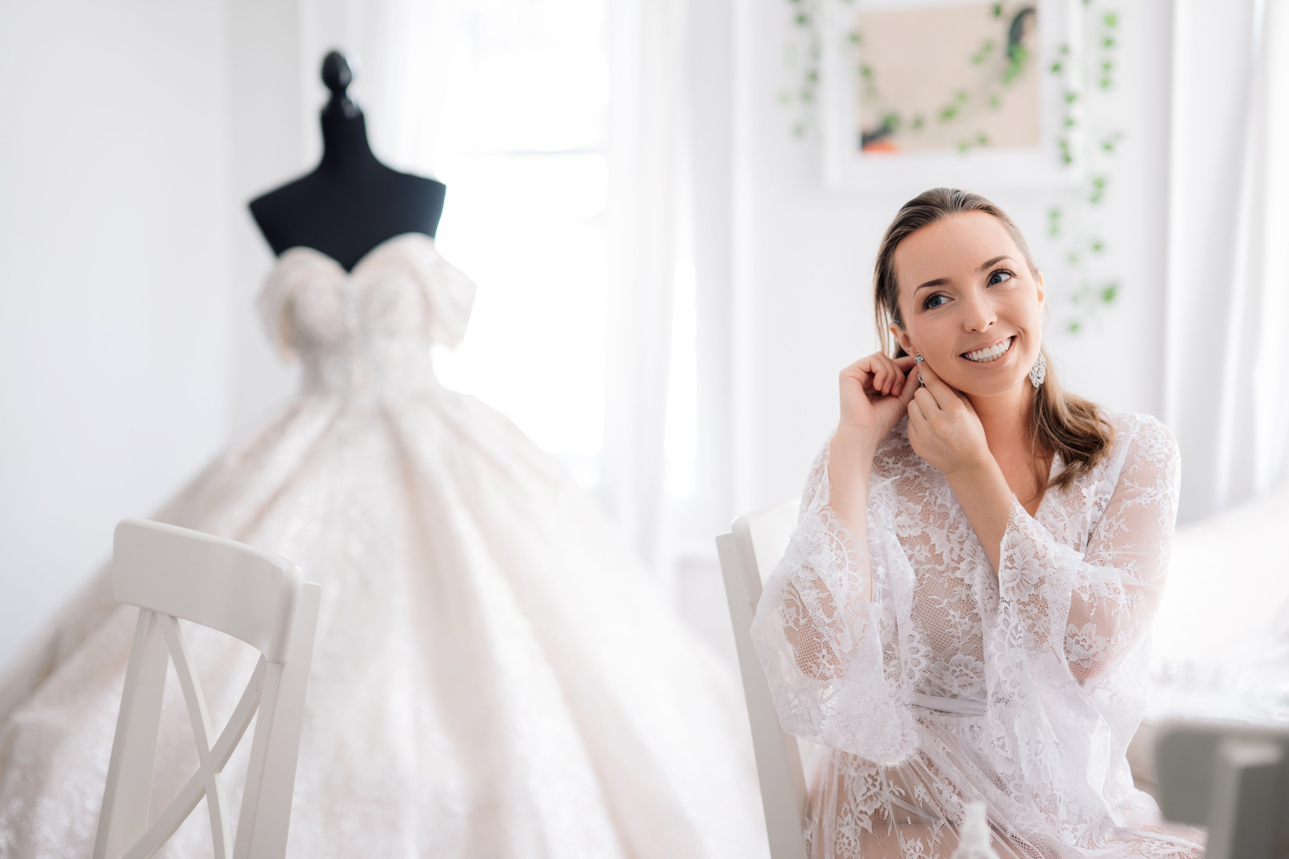 a woman sitting on a chair in front of a wedding dress