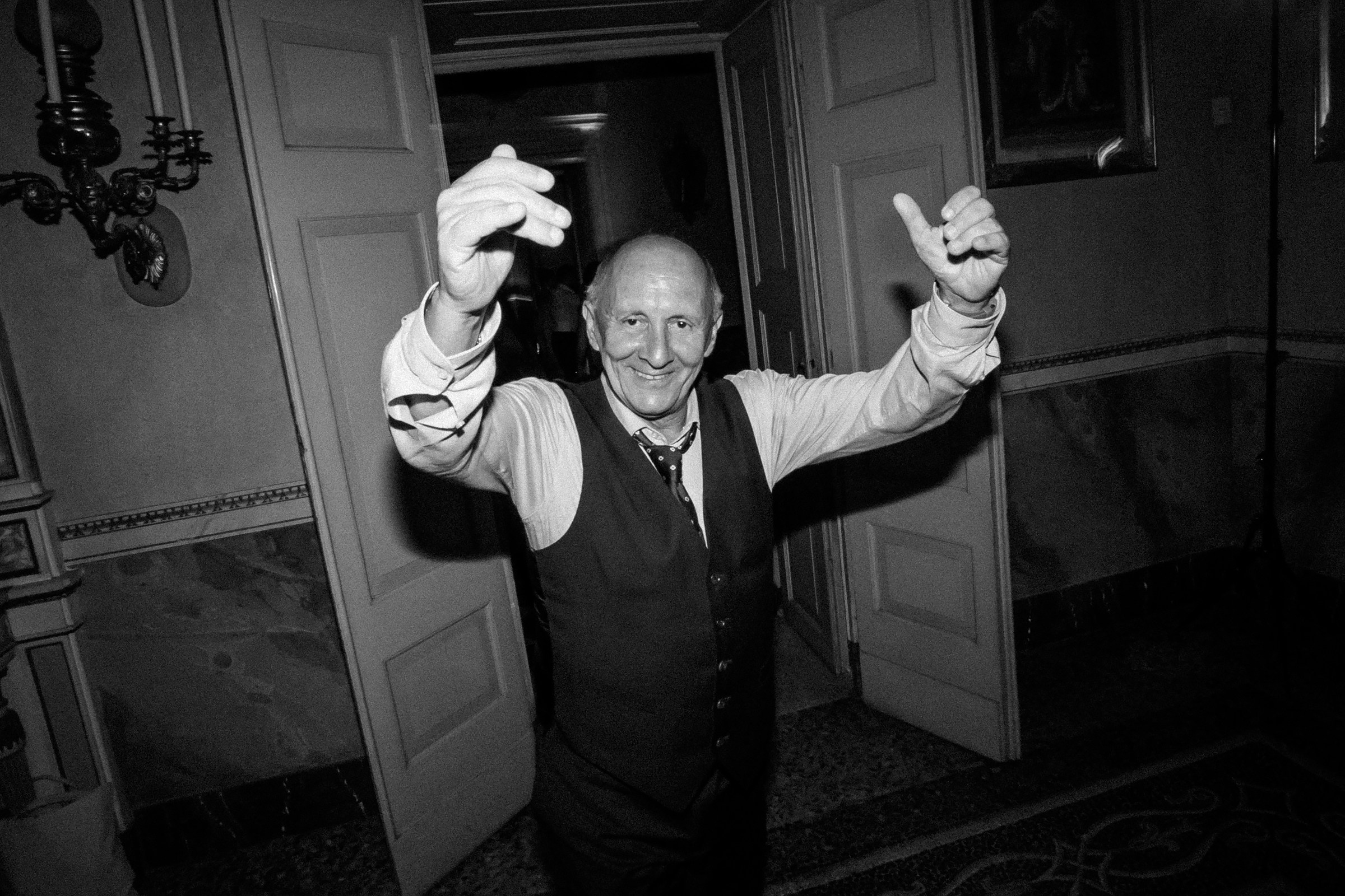 Guest enjoying the wedding, smiling and dancing with lively gestures in classic attire.
