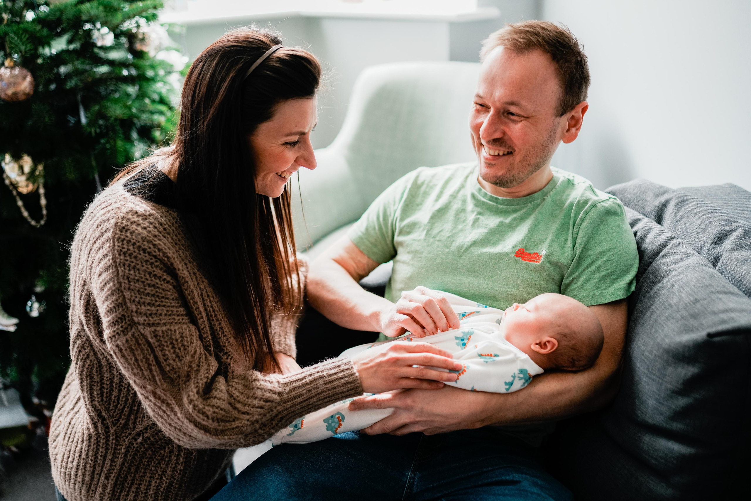 Couple holding newborn baby. Newborn photography at home.