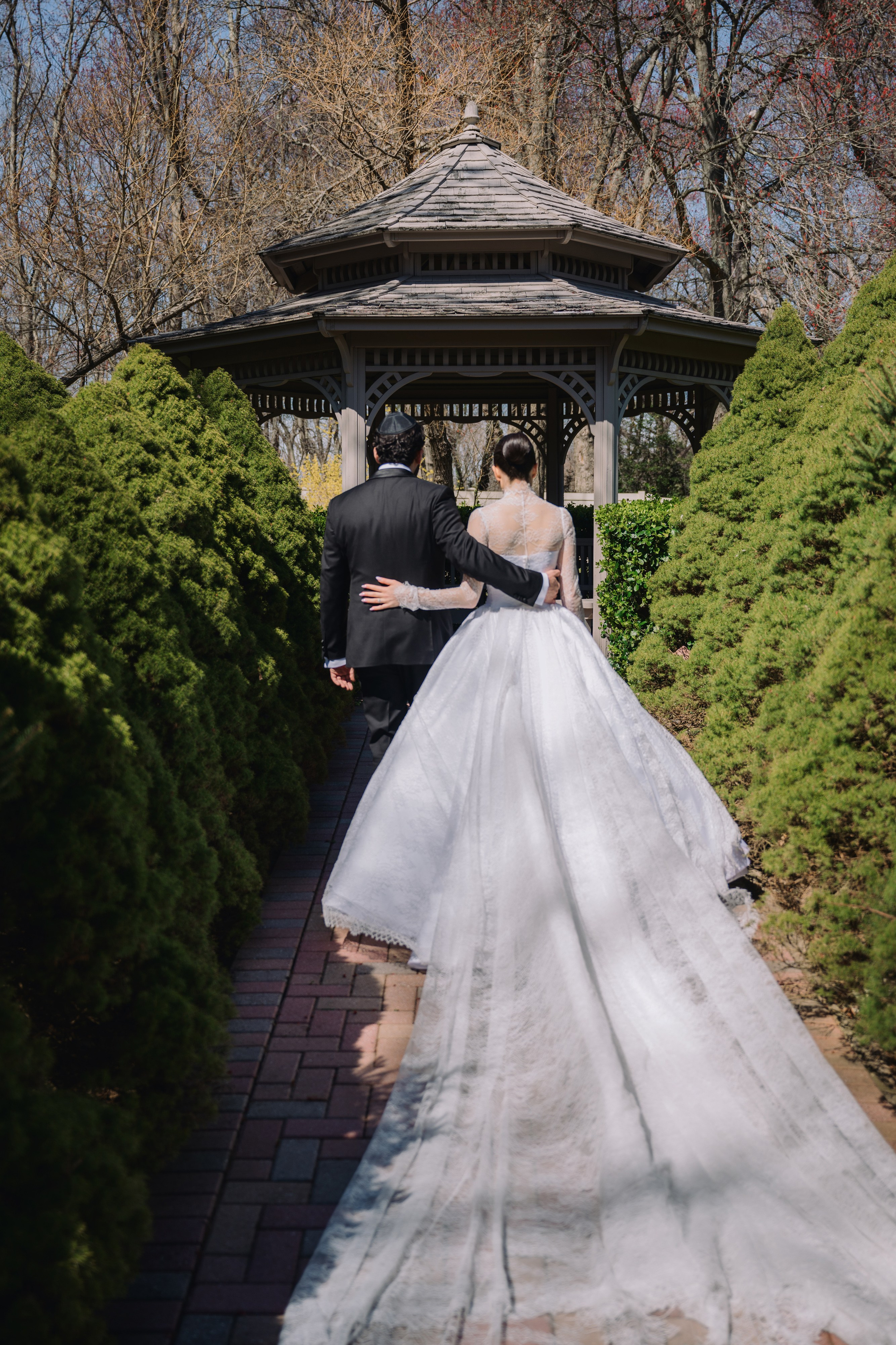 a bride and groom walking through a gaze