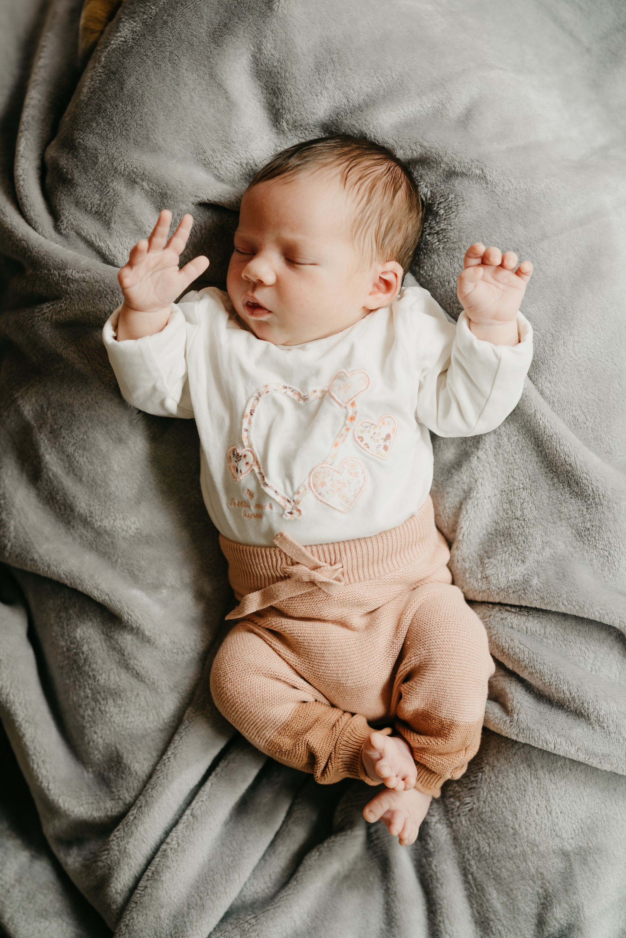 ein Neugeborenes schläft mit einem Lächeln auf die Lippen