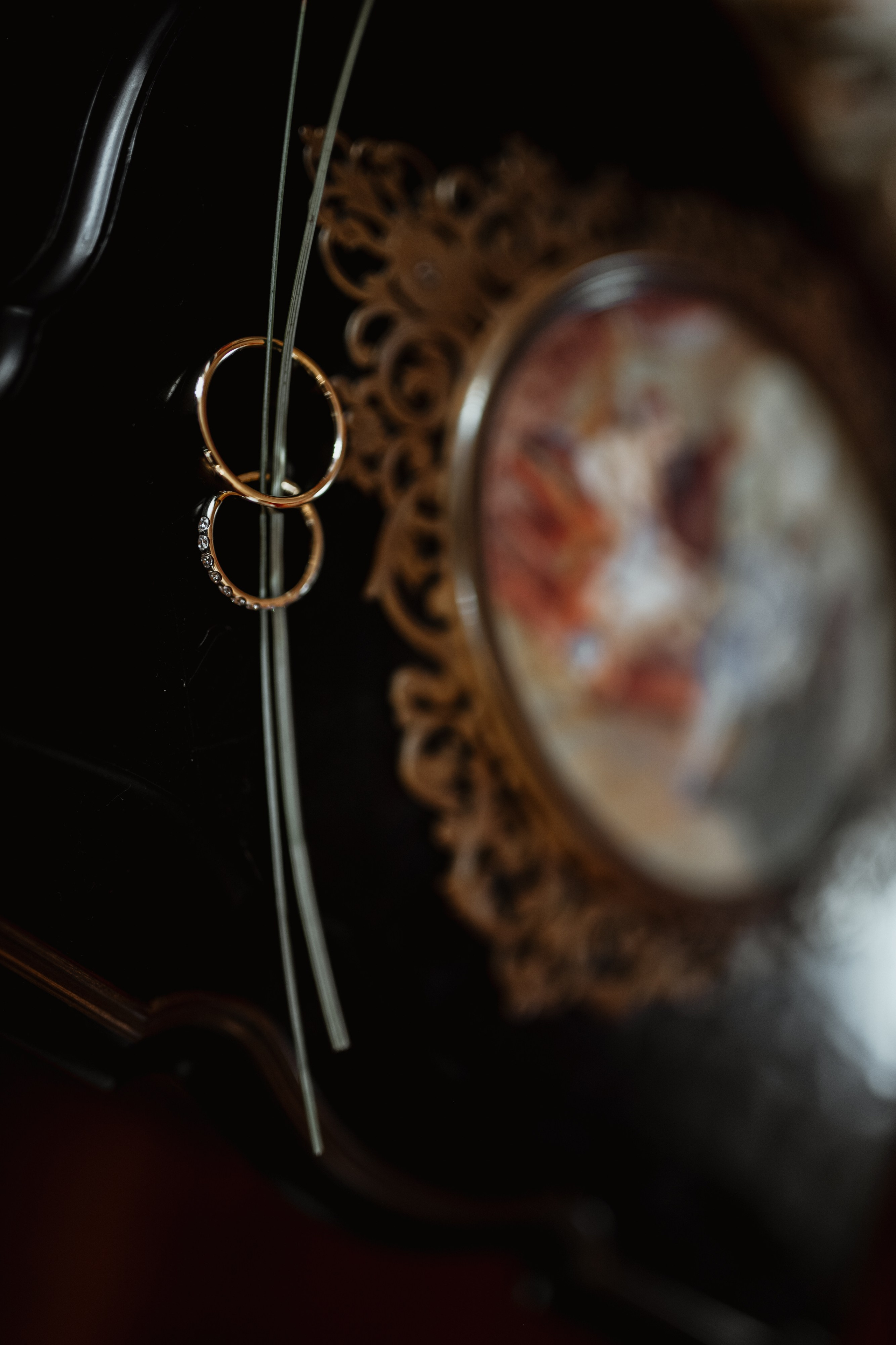 Detailaufnahme des Hochzeitsrings von Celine, der auf einem eleganten Tisch mit Hochzeitsdekoration liegt.