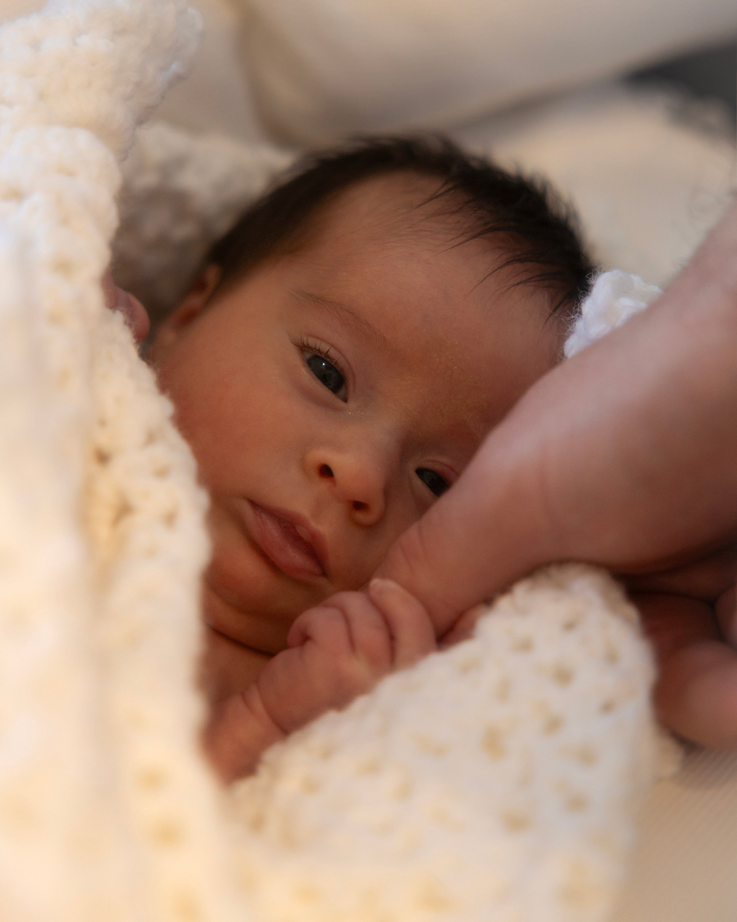 Close-up of baby’s tiny fingers holding mother’s hand, emotional family moment