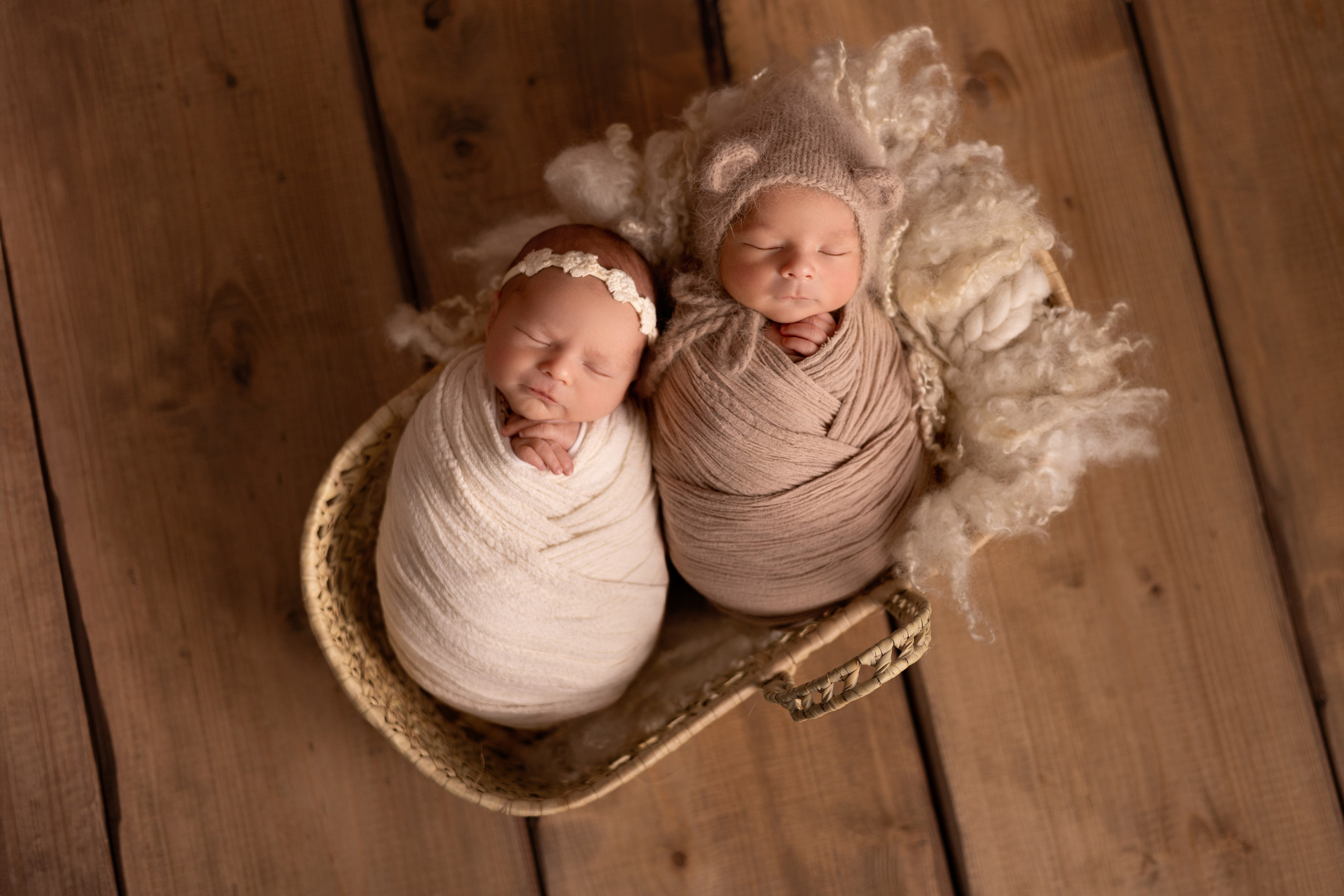 Frisch geborenes Baby eingewickelt in eine Decke, liegt in einem rustikalen Körbchen – Newbornfotografie in Iserlohn