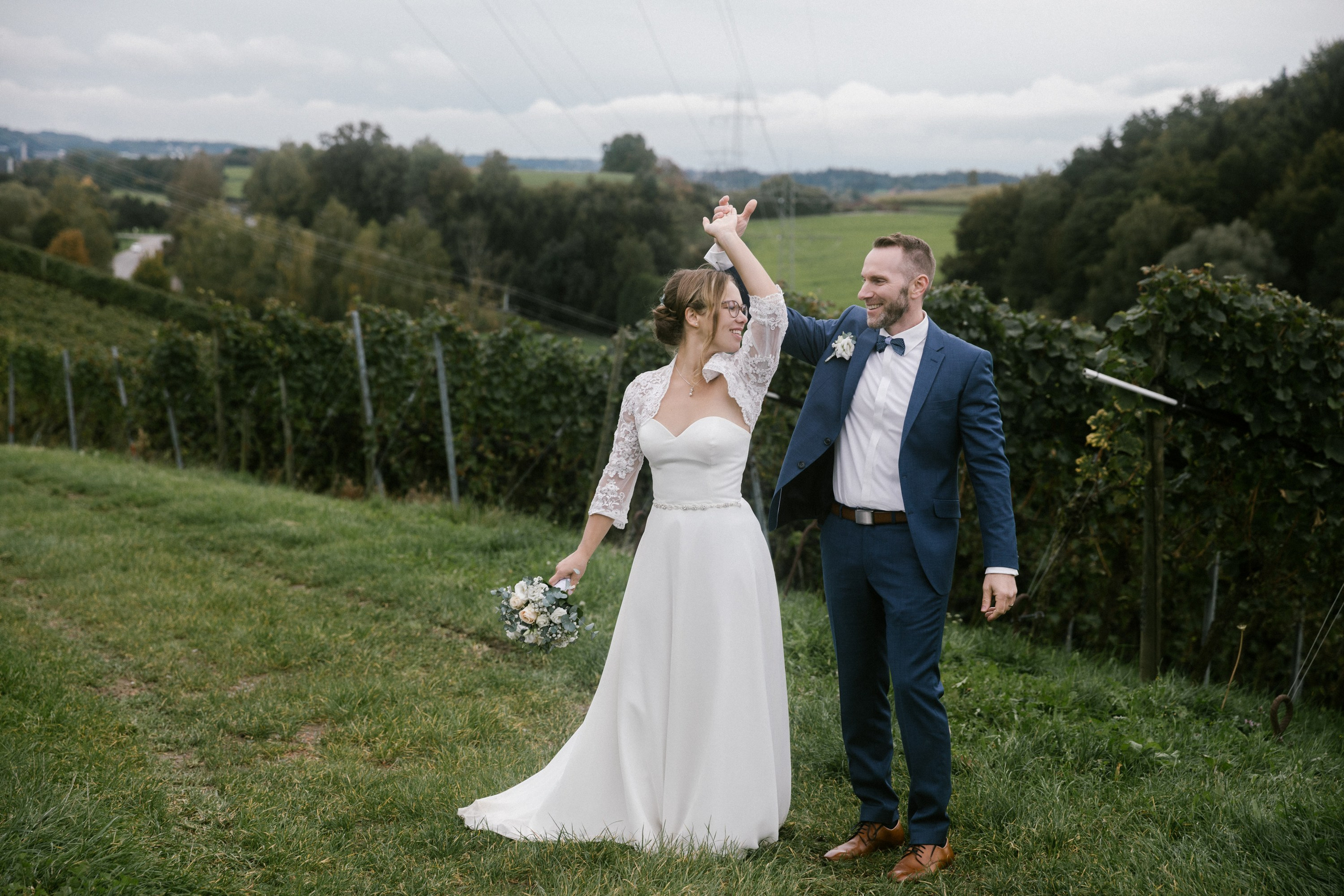 Frischvermählte tanzen fröhlich zwischen den Weinreben von Markdorf