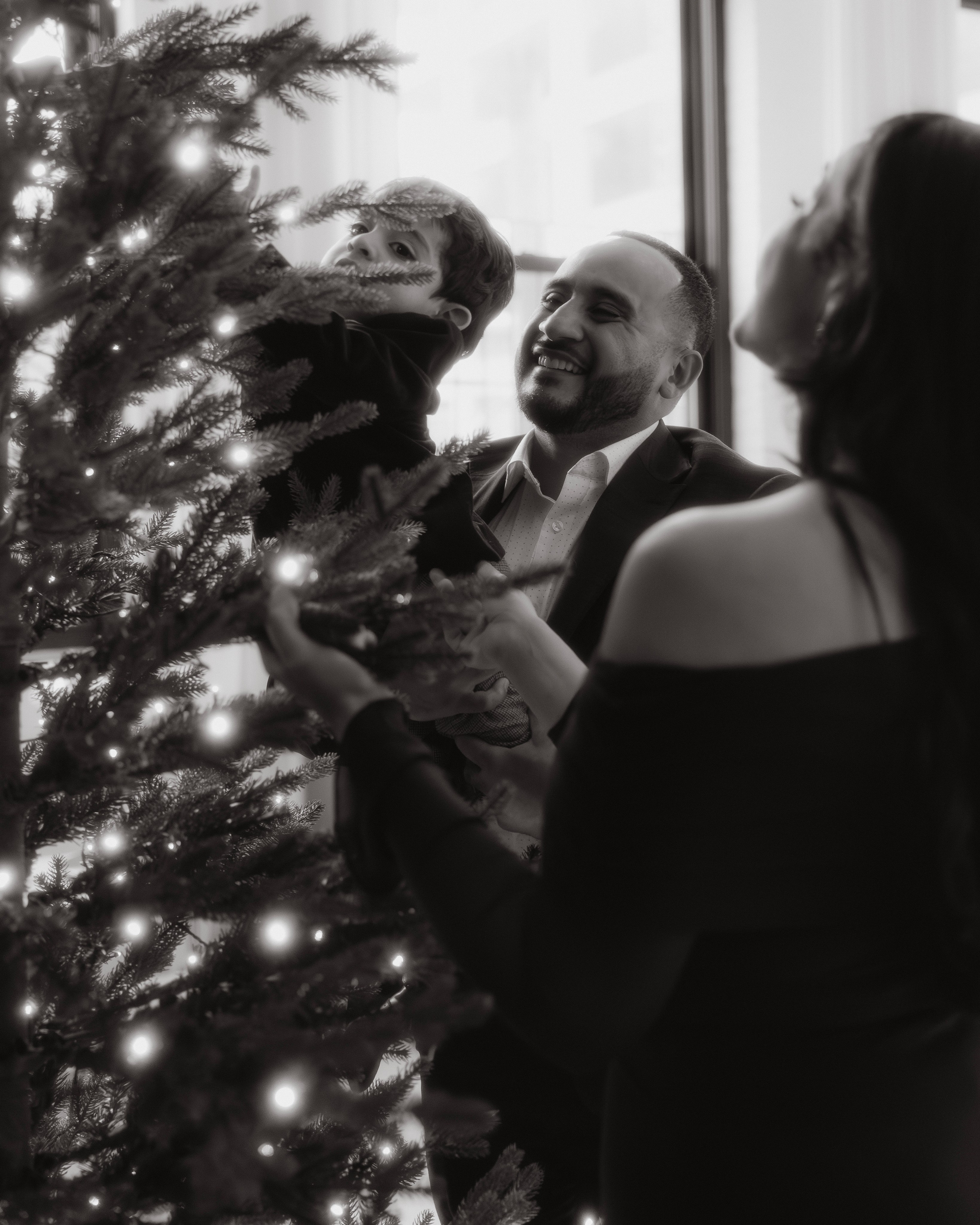Dad lifting toddler in Christmas decorated studio