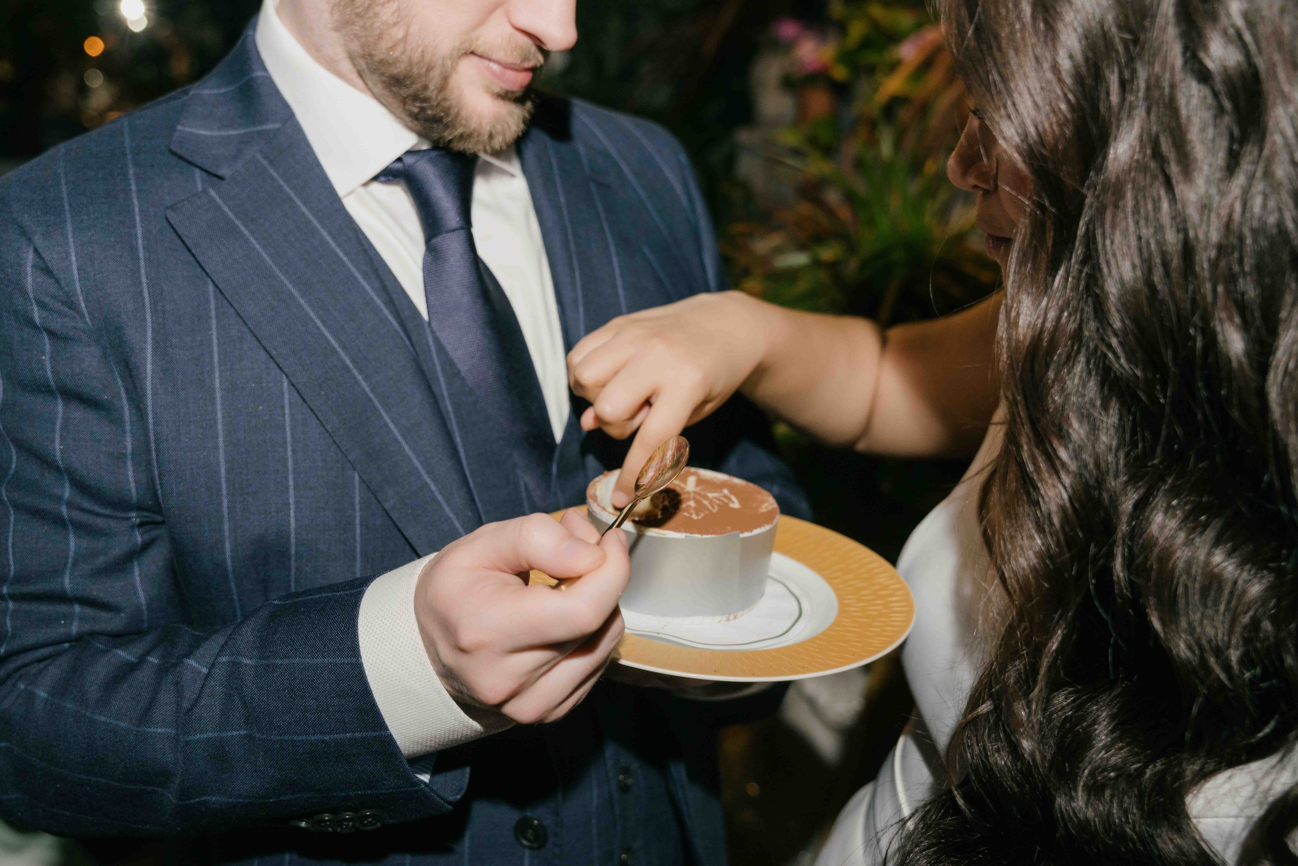 Intimate wedding reception at The Ivy London, bride and groom sharing cake, warm and elegant atmosphere