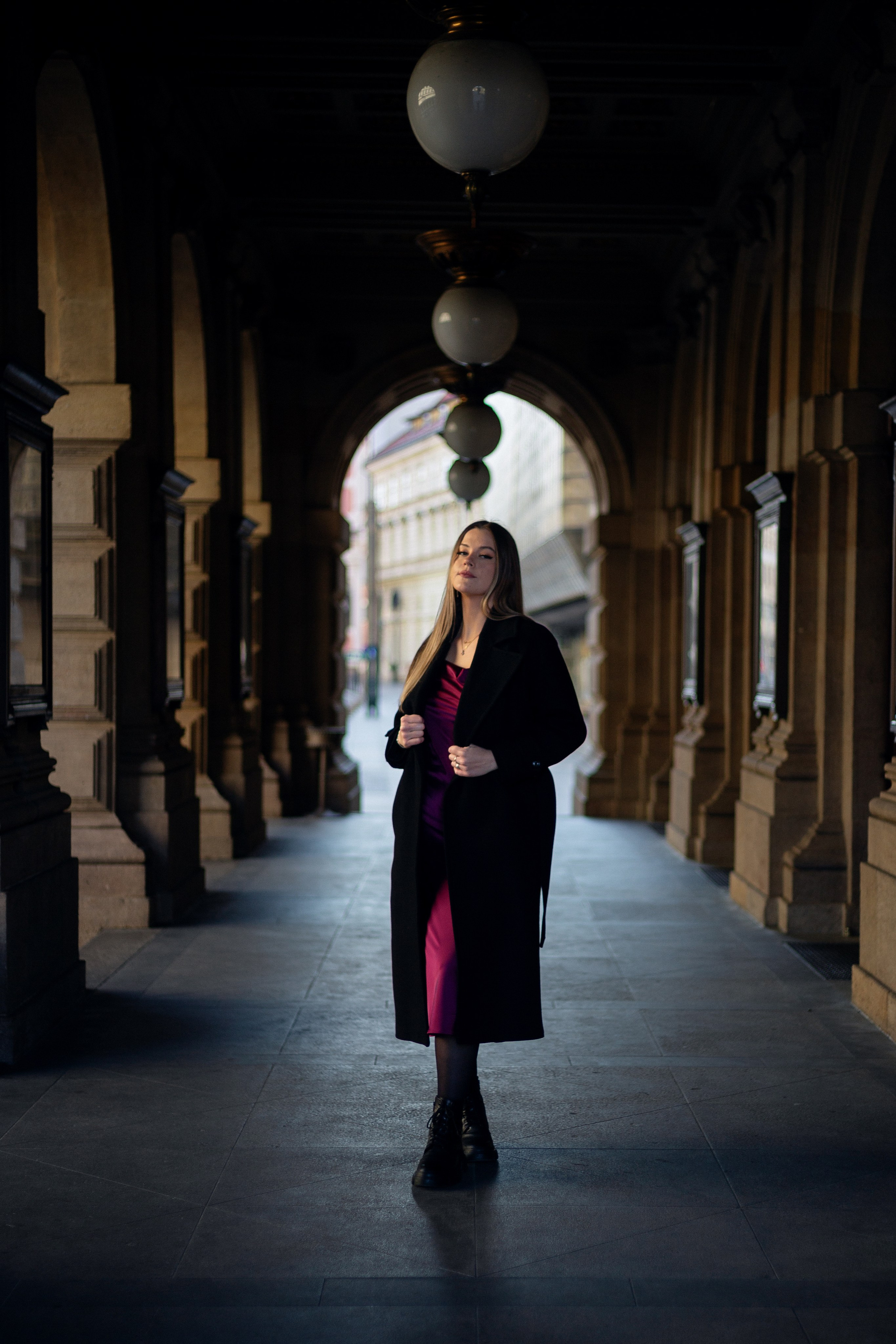 a full-length photo of a girl in front of a Prague theater